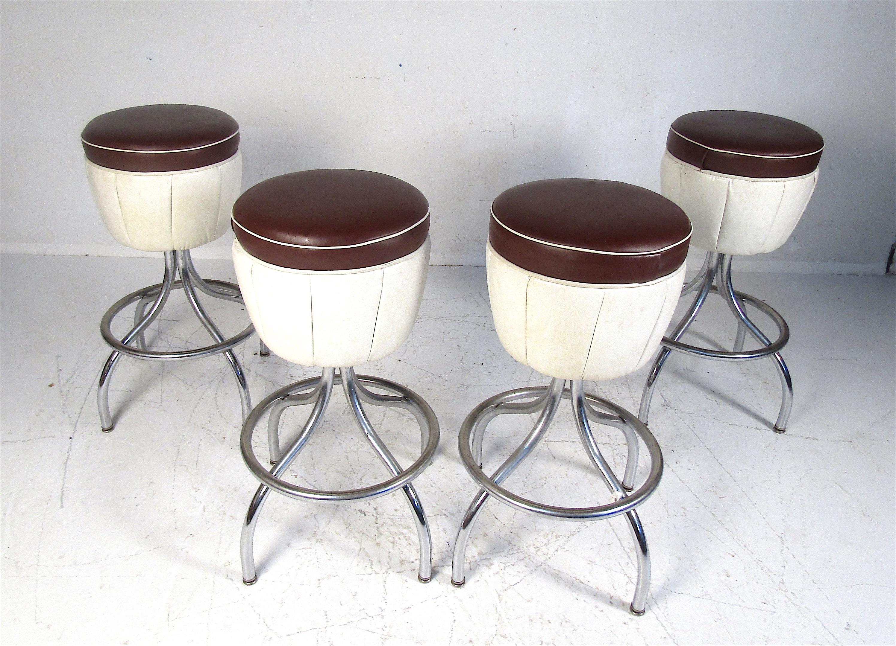 This stunning set of four vintage modern bar stools feature a backless seat and a chrome base with a footrest. The two-tone vinyl is sure to complement any setting. Please confirm the item location (NY or NJ).