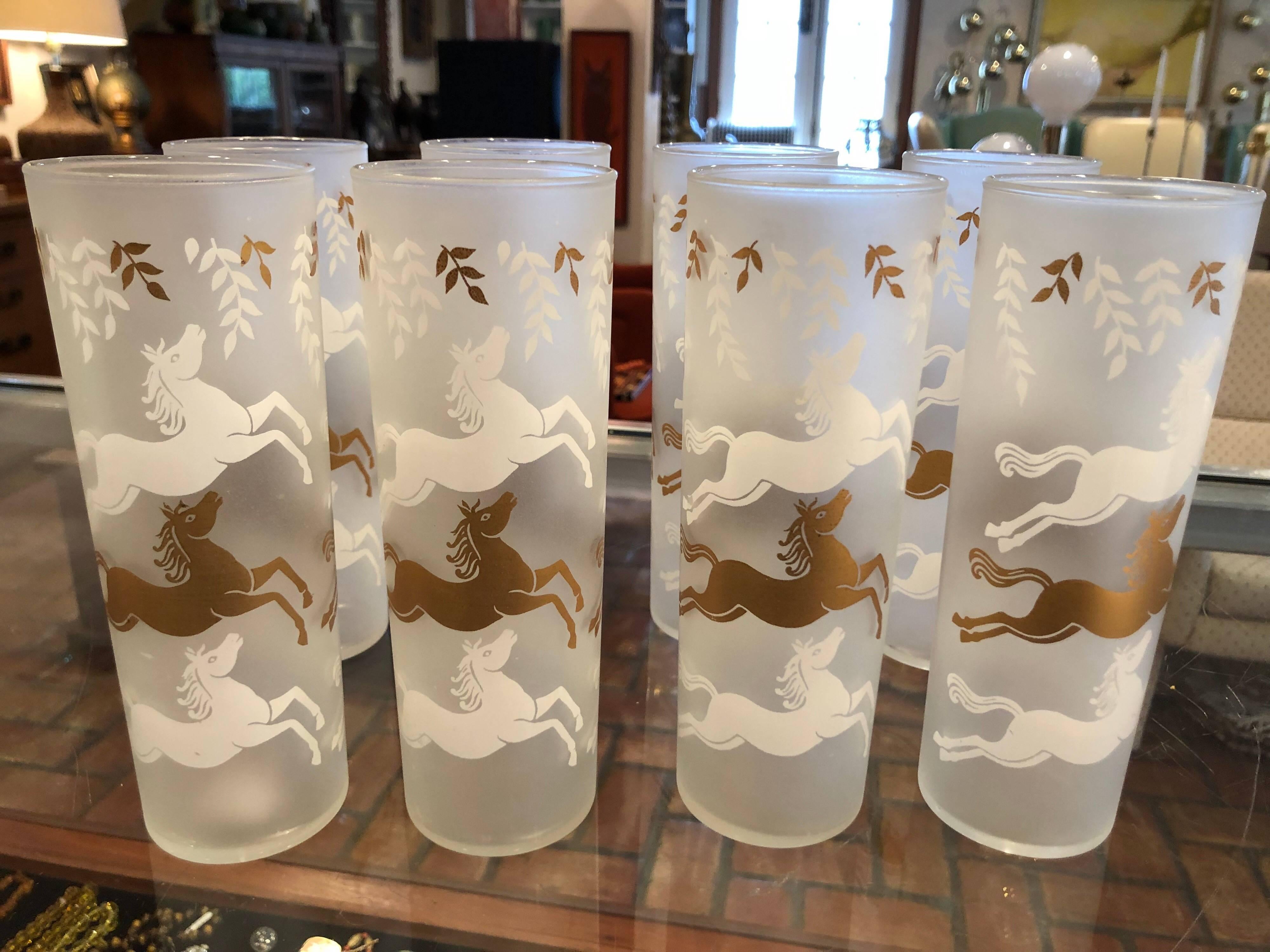 Set of Mid-Century Modern frosted horse high ball glasses. Fabulous and fun set to enjoy a cocktail or two with. Set of eight plus one. So nine altogether. The maker is Libbey. With a frosted white and gold toned cavalcade of stallions. These Tom