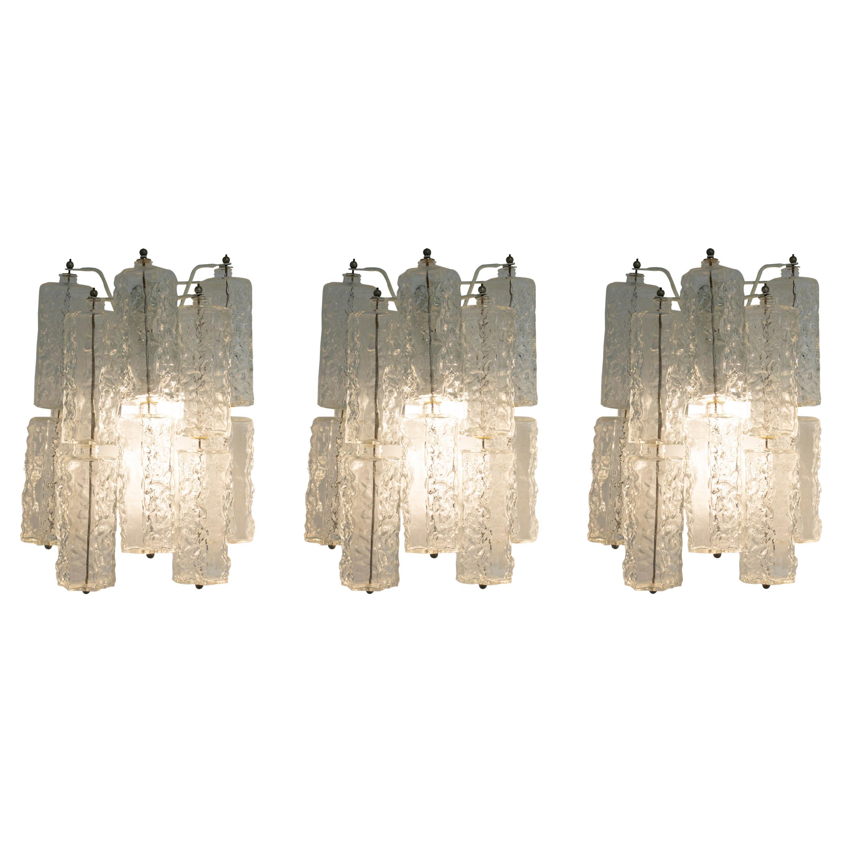 Set of three handmade transparent Venini glass wall lamps. 
Each lamp consists of 10 individual pentagonal prisms glass pieces and a lacquered metal structure and details.
