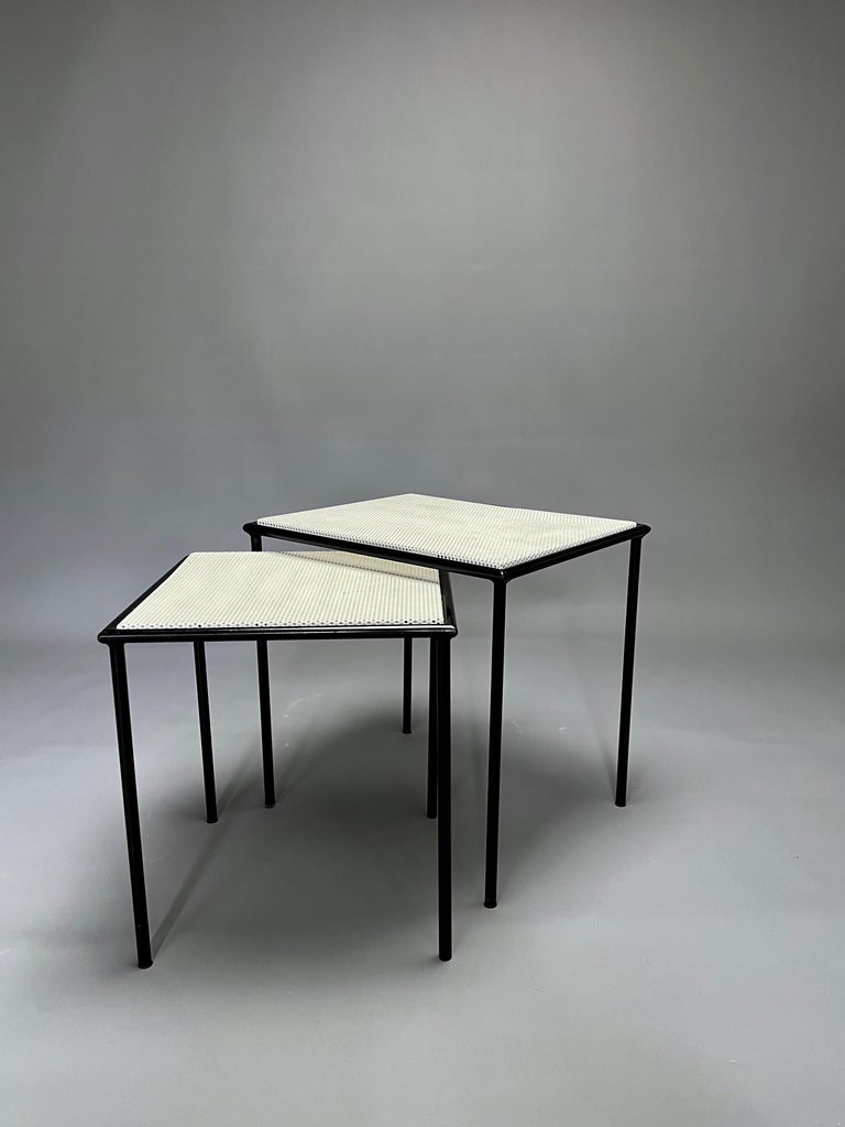 Lovely pair of side tables from Artimeta. They're small masterpieces constructed of a solid material (metal) but with an airy appeal.
The tops are made of perforated metal, in egg shell white. The base is made of tubular steel in black. This black
