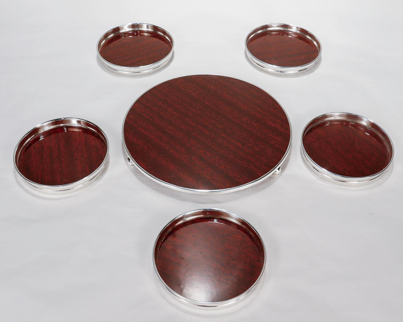 A fine set of coasters for the bar or table.

In sterling silver.

With mahogany toned wood laminate centers for each.

Comprising 1 bottle coasters and 5 individual coasters.

Perfect for your favorite cocktail or wine evening!

Date:
Mid-20th