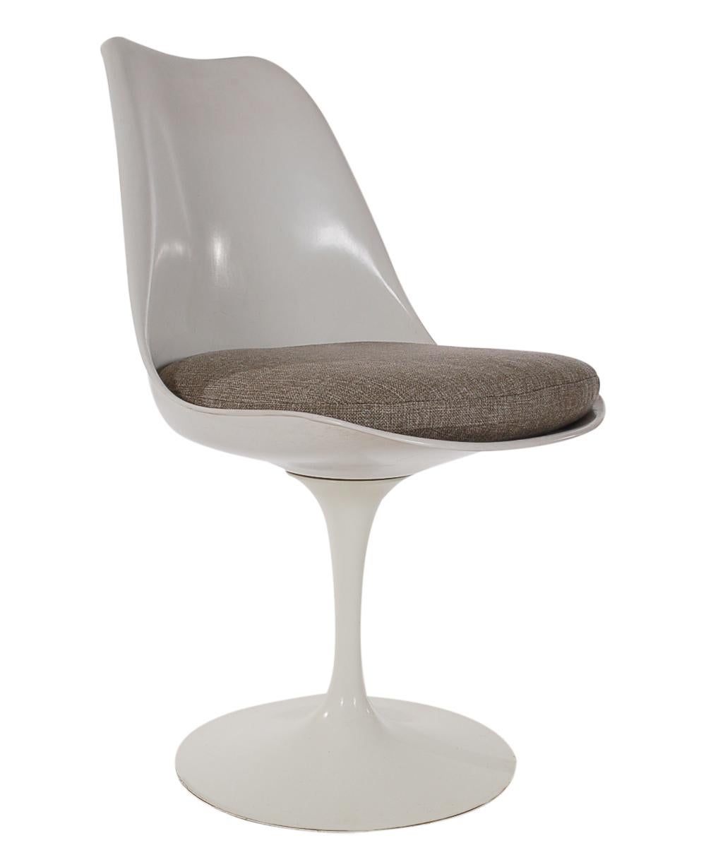A beautiful vintage set of white tulip chairs designed by Eero Saarinen and produced by Knoll Associates. These chairs feature cast aluminum swiveling bases, fiberglass seats, and newly recovered seat cushions. All very clean condition and ready for