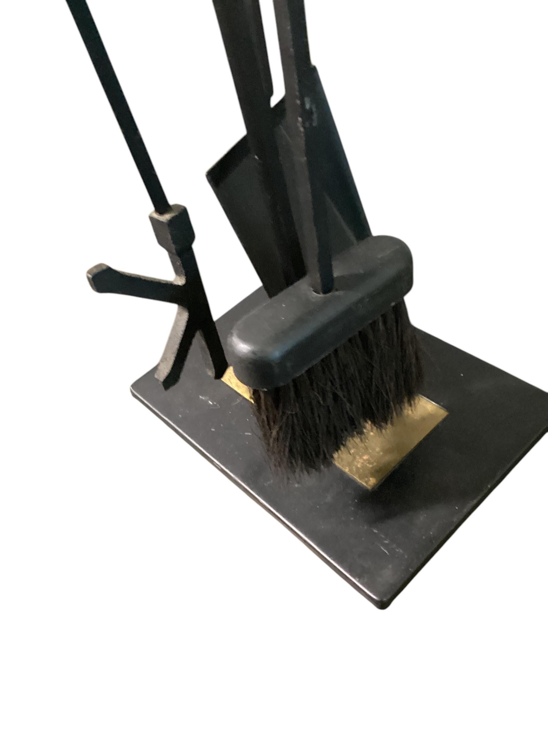 Set di attrezzi per caminetto in ottone e ferro in stile Mid Century Modernist di Paul McCobb. Il set è composto da una spazzola, un attizzatoio e una pala. Il set è rifinito in ottone e sormontato da terminali in ottone.