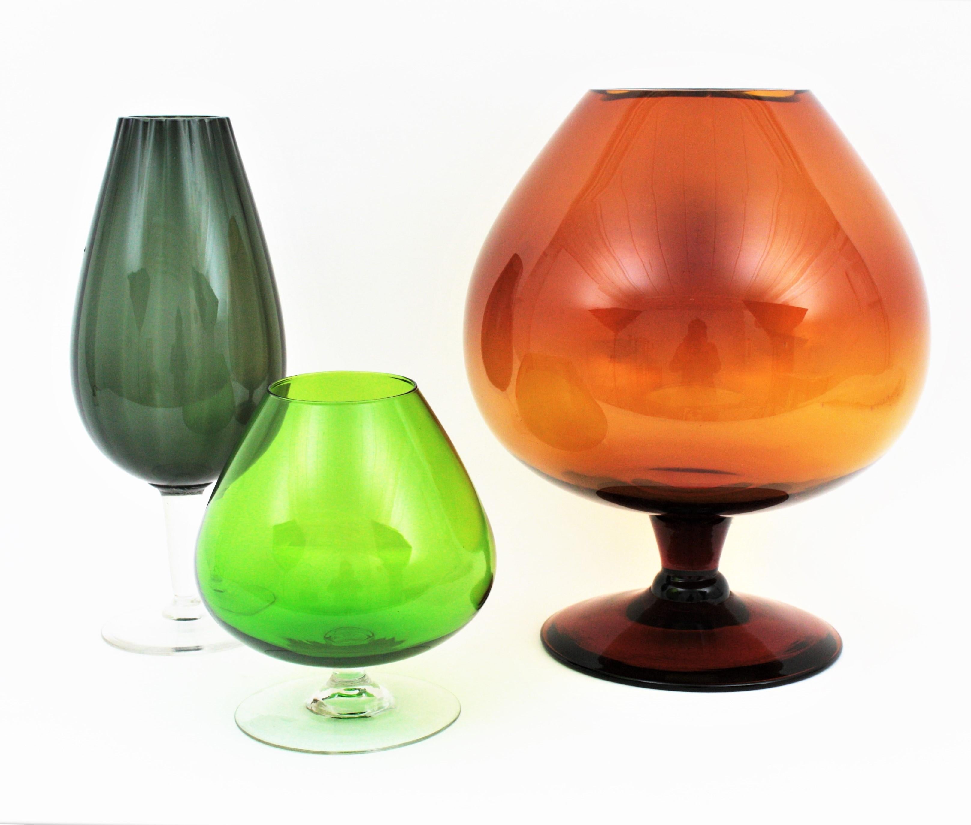 Eye-catching set of Magnum size amber, green and petrol green cocktail glasses, Spain, 1960s
This set is formed by an unusual extra large amber brandy balloon glass, a vibrant green large balloon glass and a petroleum green large cocktail