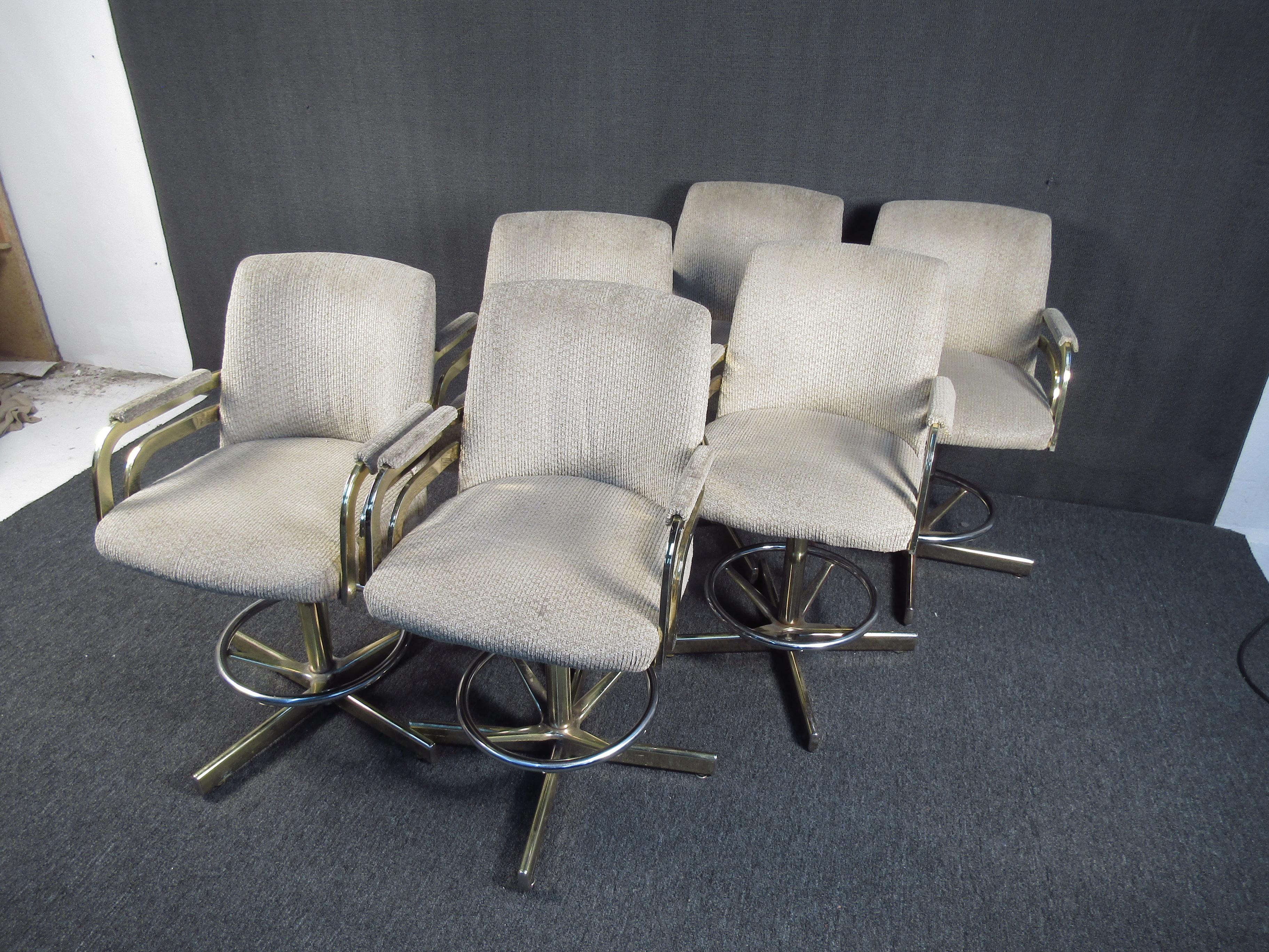 This beautiful set of brass and armchairs styled after the designs of Milo Baughman features elegant brass frames with very comfortable upholstered seats. Additionally, each seat has a footrest as well as a swivel function. Please confirm the item's