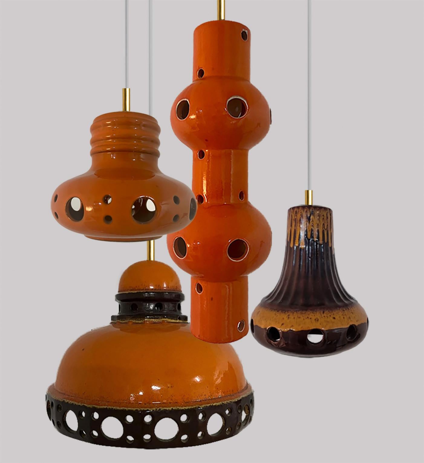 Un ensemble de lampes suspendues en céramique, spectaculaires et élégantes, fabriquées en Allemagne de l'Ouest vers les années 1970. Les lampes sont fabriquées en céramique émaillée orange et marron et émaillées dans le style 