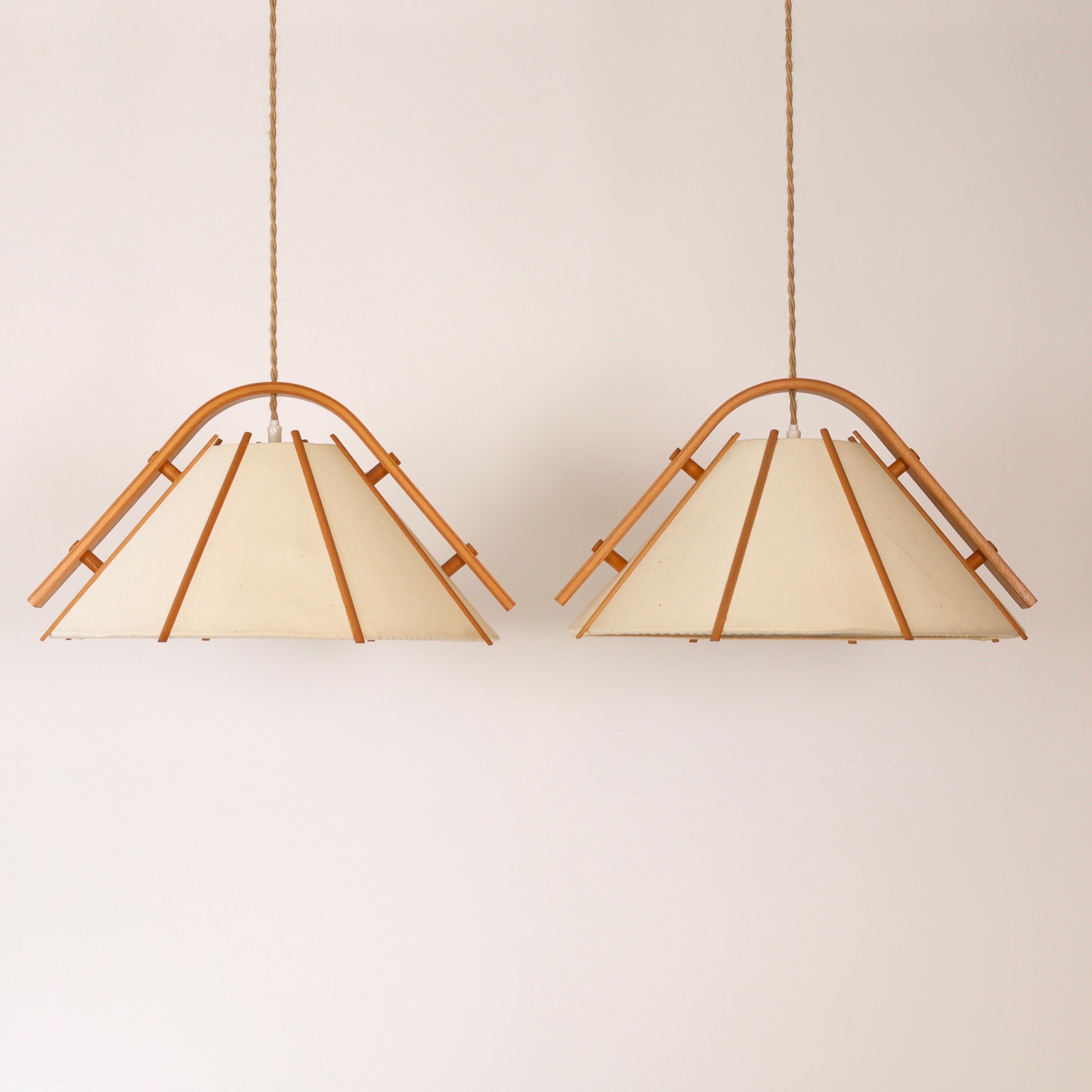 Set of pendant lights in bend Beech wood and Canvas designed by Jan Wickelgren in the 1970s for Aneta Sweden. A set of scandinavian lights to a beautiful space. 

* A set (2) of pendant lights in bend beech veneer and beige canvas shades
* Designer: