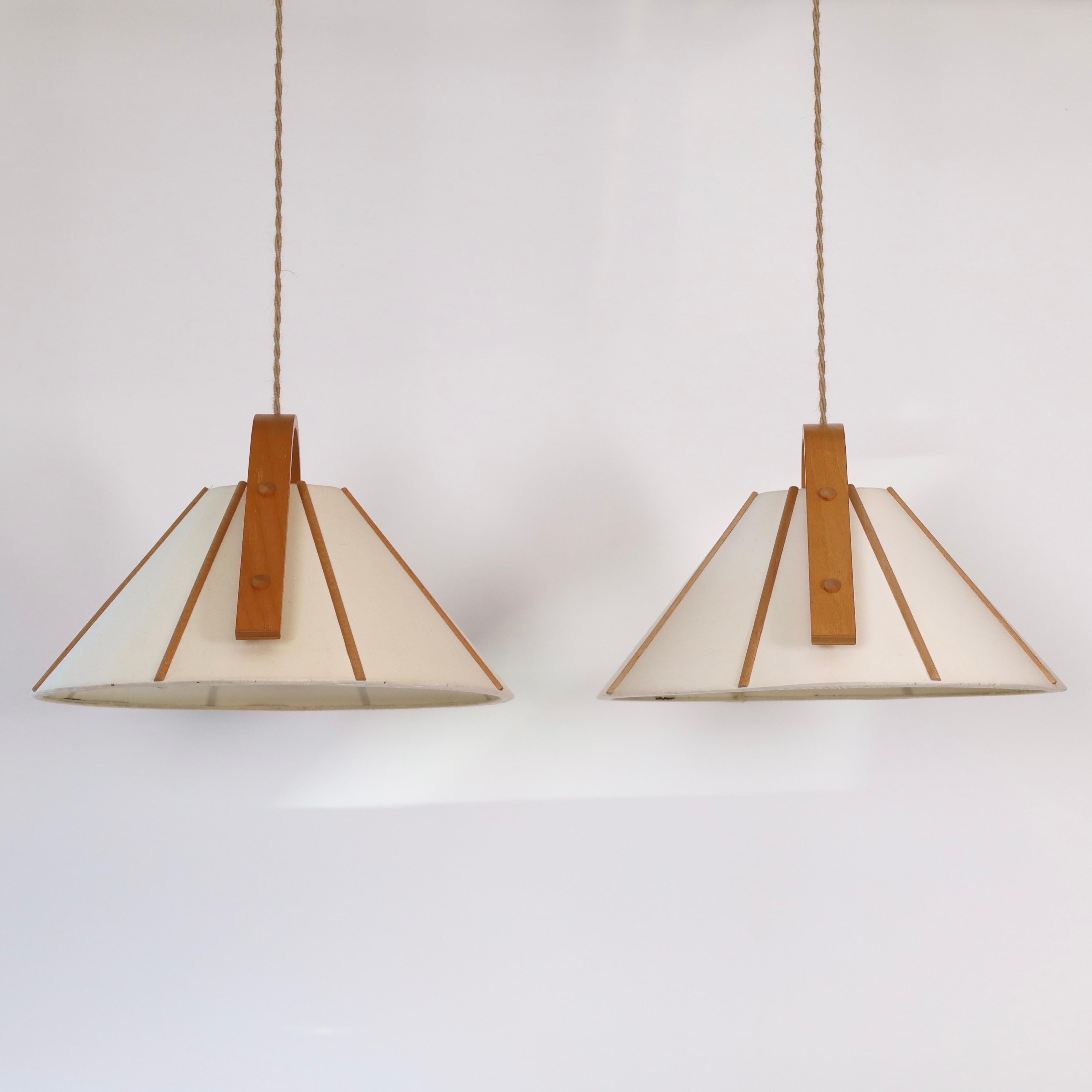 Set of pendant lights in bend Beech wood and Canvas designed by Jan Wickelgren in the 1970s for Aneta Sweden. A scandinavian light to a beautiful space.

* A set (2) of pendant lights in bend beech veneer and beige canvas shades.
* Designer: Jan