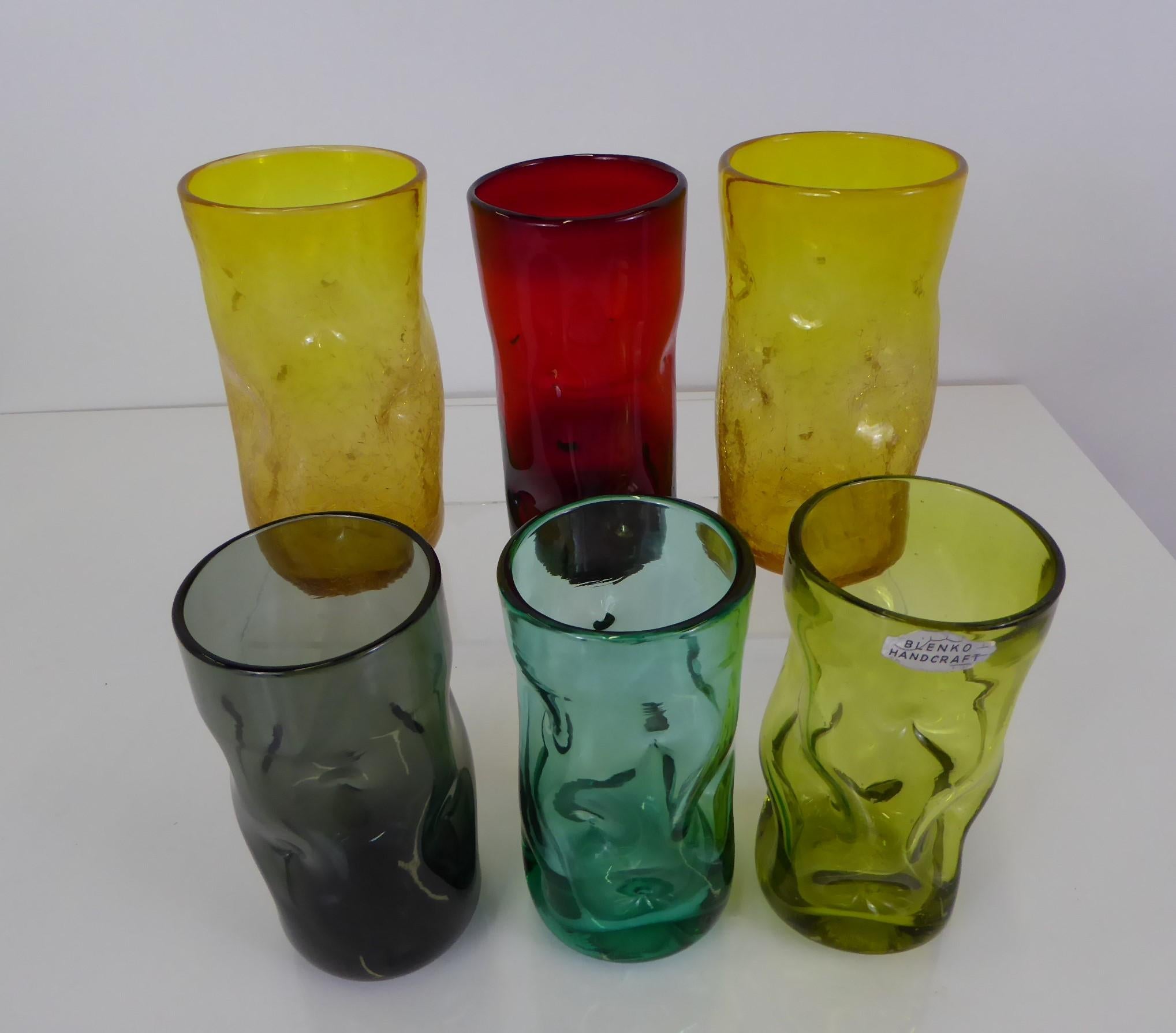 Here a grouping of 5 pinched or dimpled mouth blown glass tumblers #418L by the Blenko Glass Co. of Milton, West Virginia. The grouping consists of 3 clear in olive, smoke and turquoise, 2 gold in crackled finish plus one red pinched tumbler of