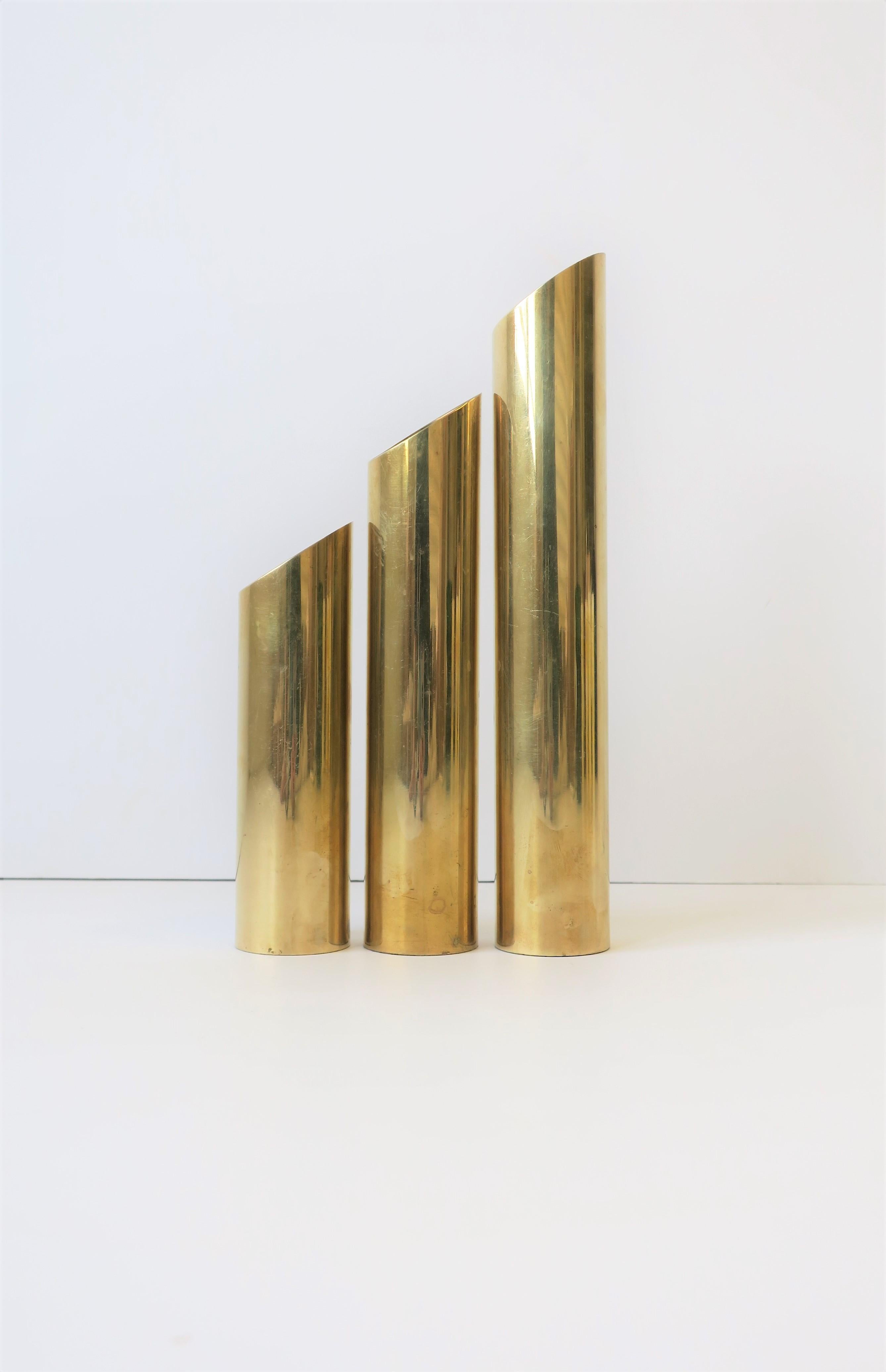 A chic set of three (3) substantial and versatile '70s modern brass cylindrical sculptures, circa 1970s Postmodern, late-20th century. Pieces are strategically weighted at bottom.

Height measurements:
10.5
