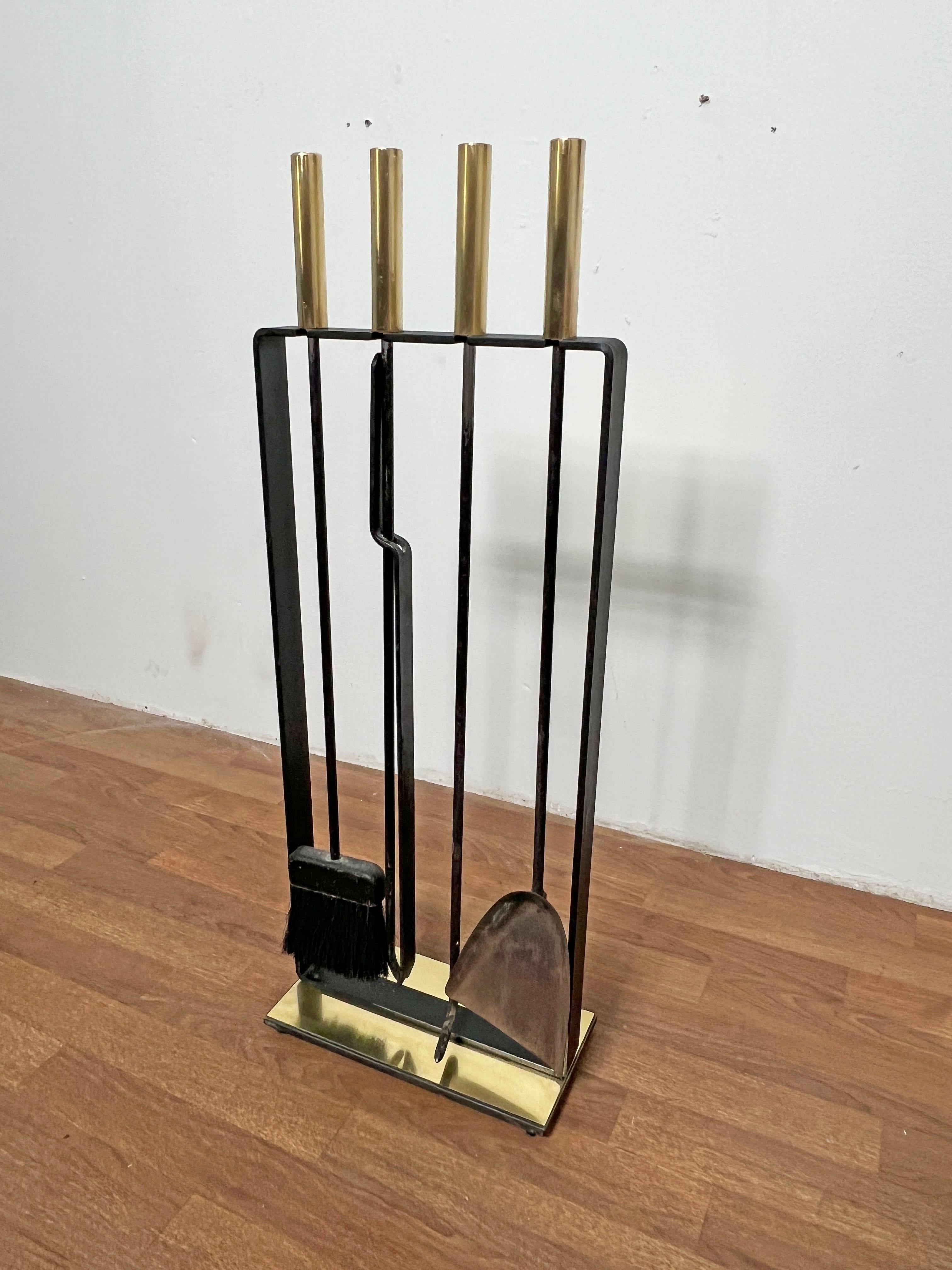 Set of four fireplace tools with stand in wrought iron with brass accented base and handles by Pilgrim Manufacturing Co., circa 1960s.