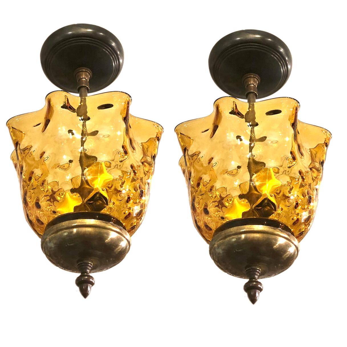 A set of three French circa 1950's molded amber glass light fixtures with two interior lights each.

Measurements:
Drop: 15
