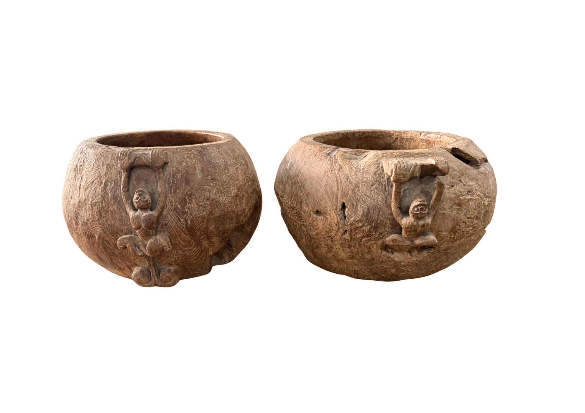 Dieses auffällige Set aus handgeschnitzten Teakholzschalen wird aus massiven Blöcken aus Wurzelholz gefertigt, einem Material, das wegen seiner Seltenheit und seiner dramatischen natürlichen Musterung sehr geschätzt wird. Maserholz entsteht, wenn