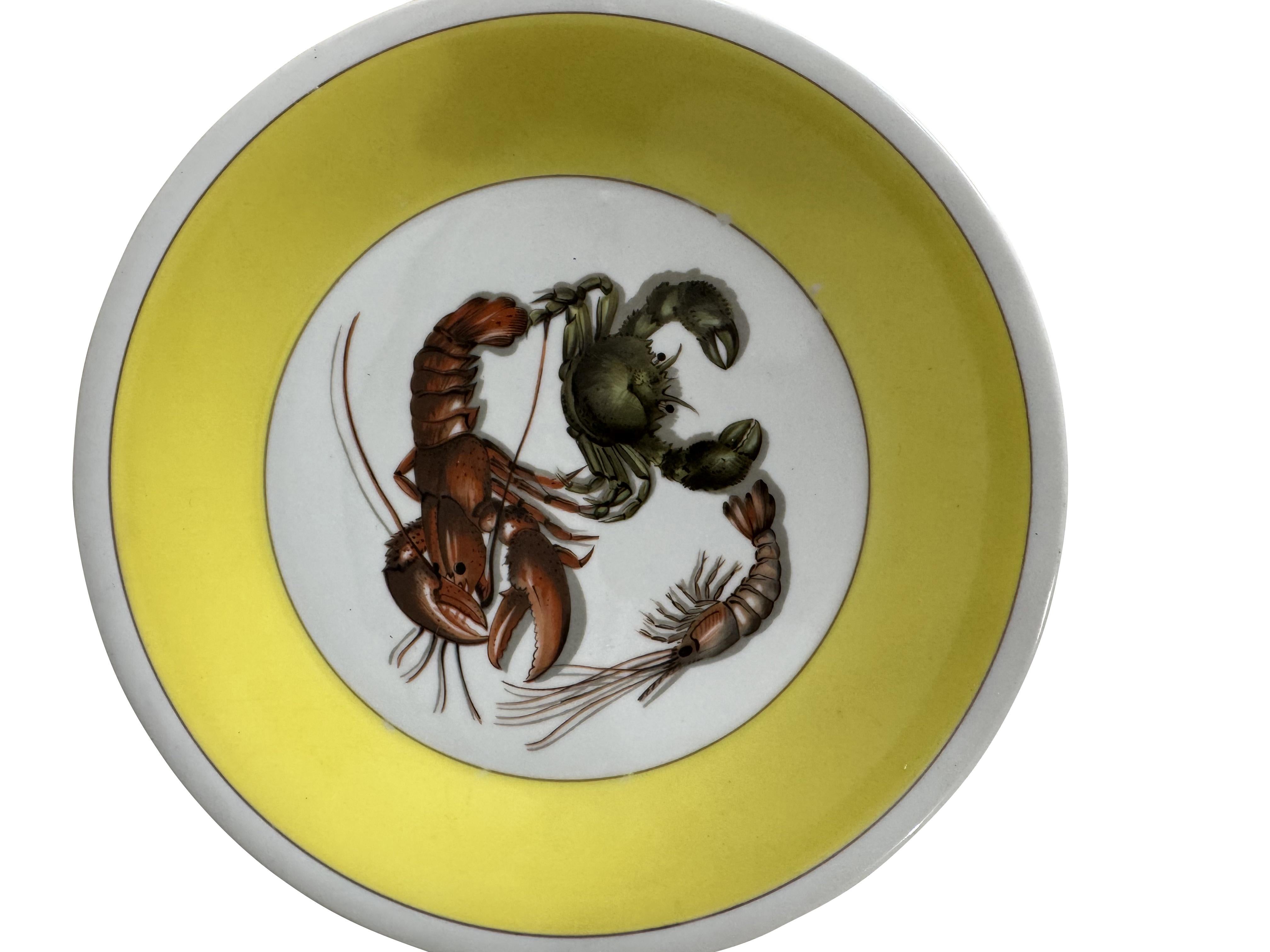 Set of Mottahedeh “Lobster and Crab” Plates and Platter
20th century

Colorful and whimsical set of eight porcelain plates and one oval serving platter by Mottahedeh, each featuring a vibrant yellow border and a central crustacean motif depicting