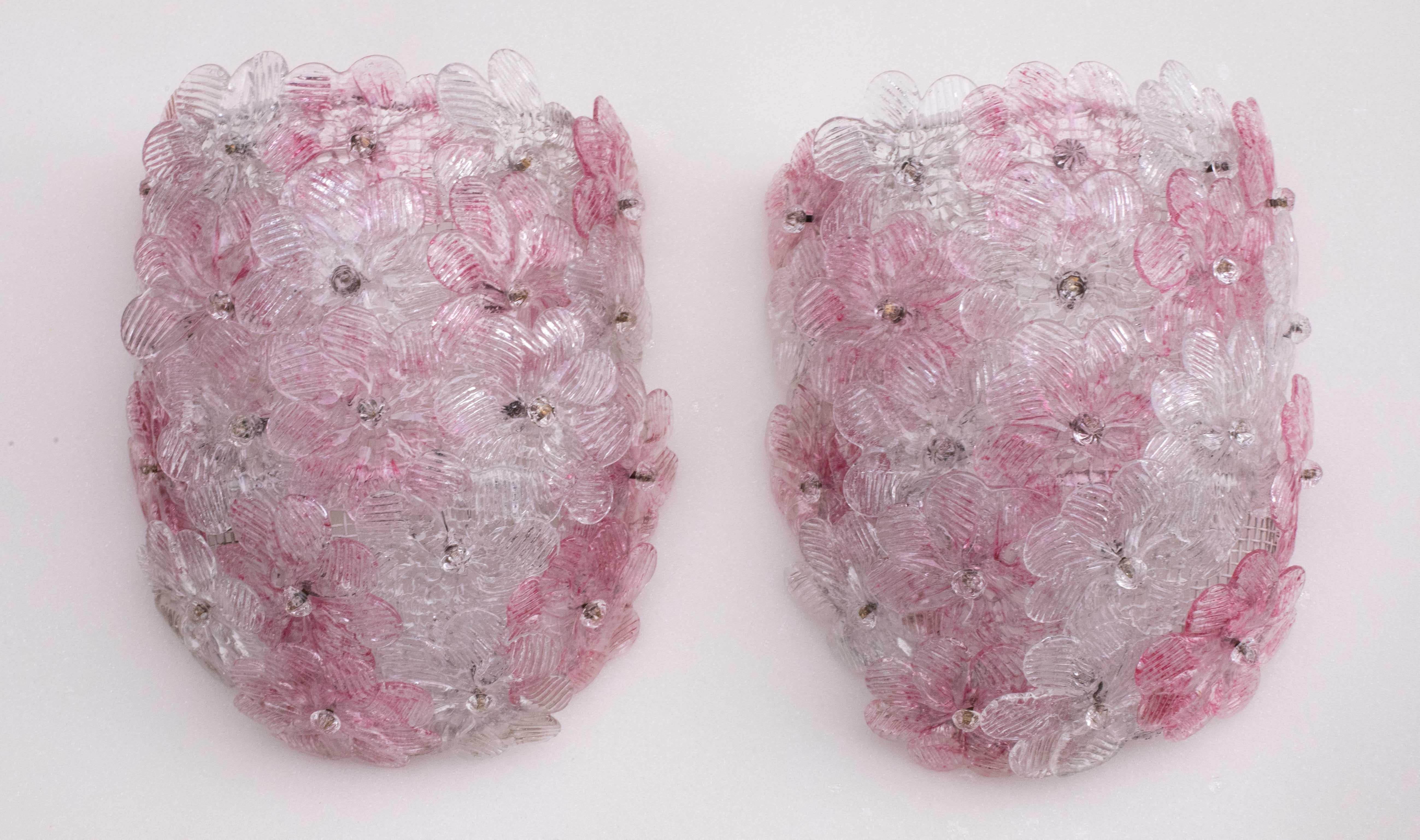 Graziosa coppia di applique con fiori in vetro di Murano, realizzate da Seguso per Venini, Italia, anni '1970.
Cestino da soffitto in metallo verniciato di bianco con fiori sovrapposti in vetro di Murano soffiato a mano di colore rosa e trasparente