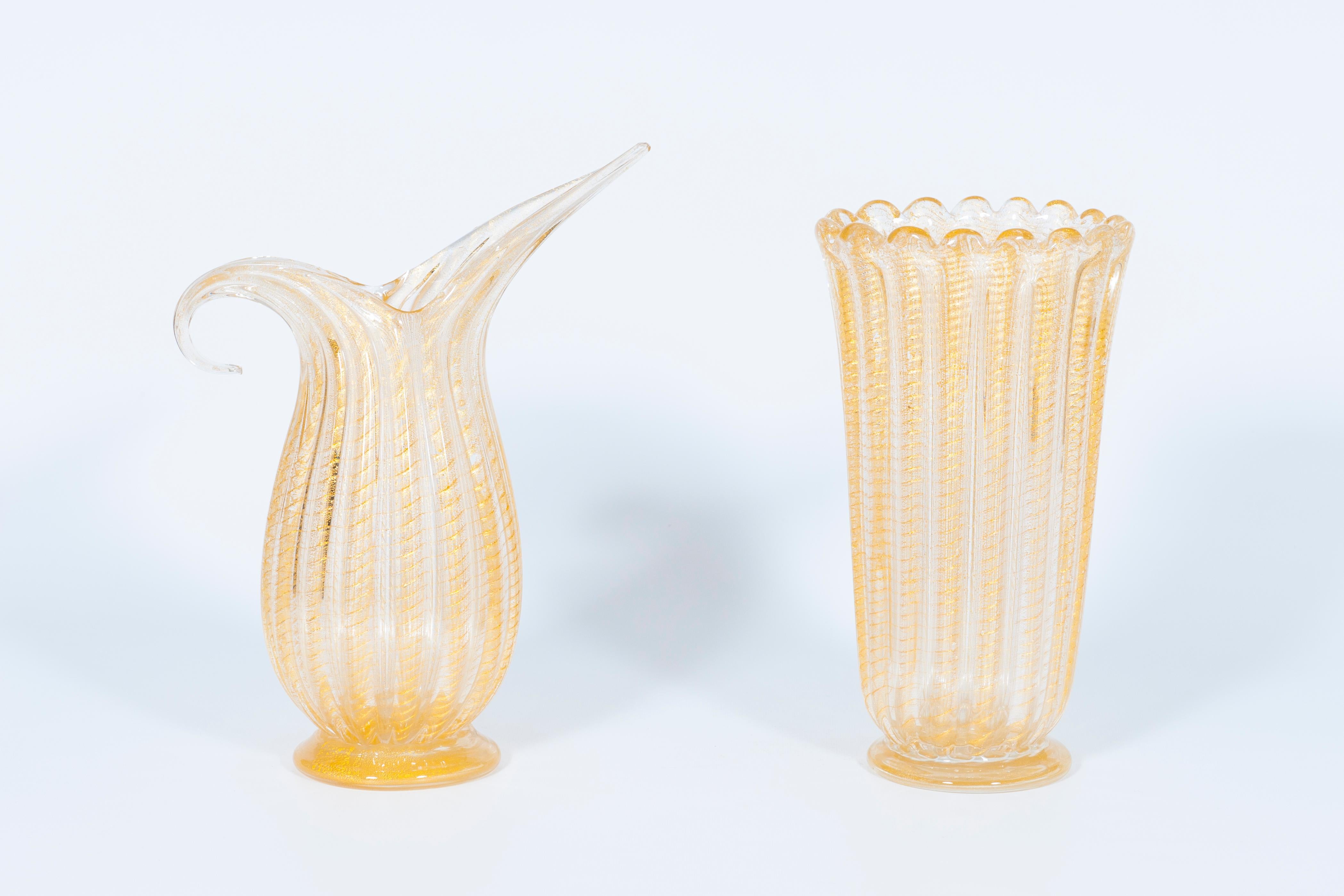 Set of Murano glass ribbed vase and pitcher with 24-karat gold, in style of Barovier, Italy, 1980s.
The masterpieces come in different shapes: one has an oval base and an undulated edge on top, while the other is a pitcher with a stylized handle