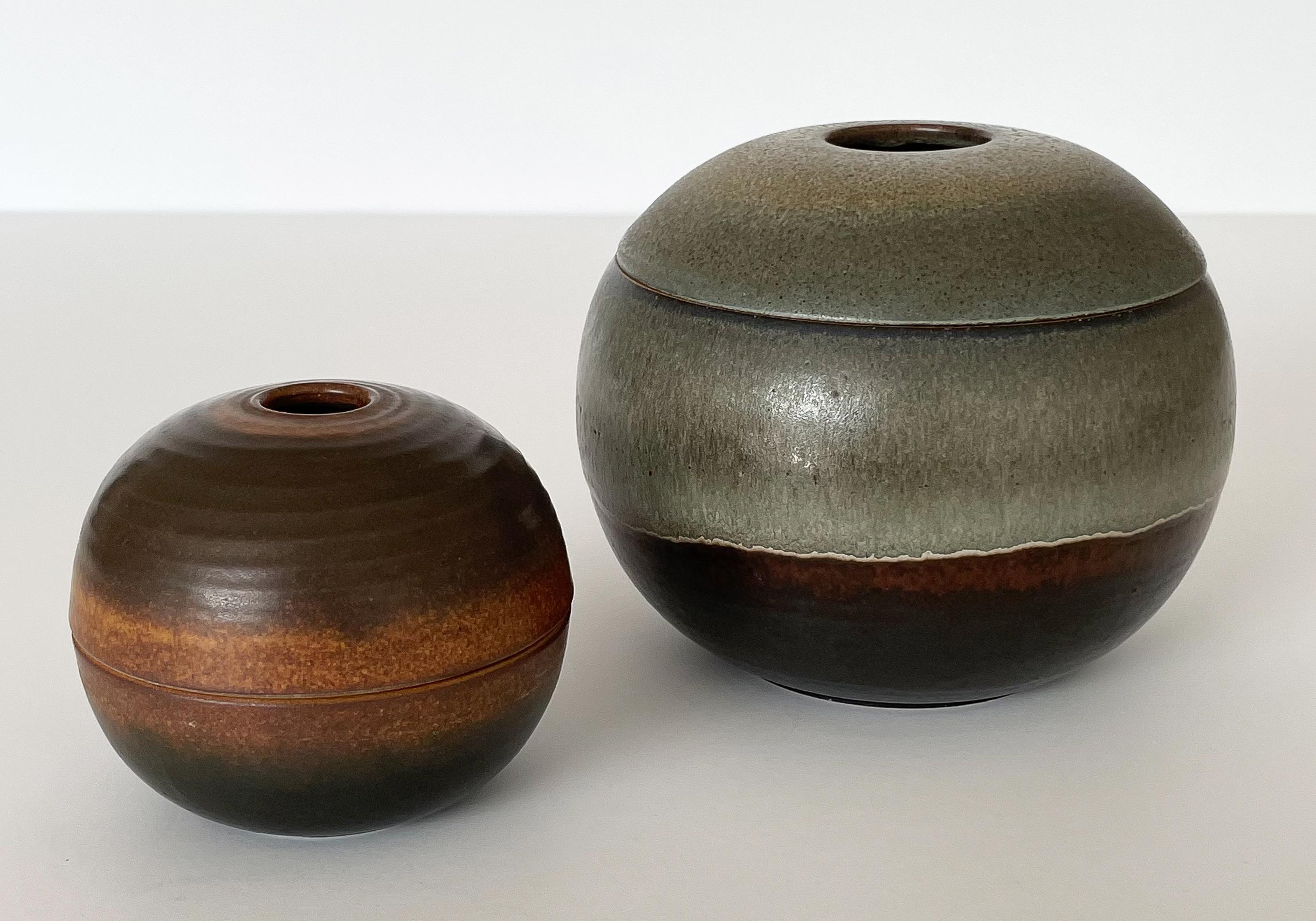 Set of two incredible Nanni Valenti ceramic sphere shaped boxes for Ceramica Arcore, Italy circa 1960s. These two ceramic lidded boxes pair extremely well together in both size and sophisticated colors. The larger box measures 5.5