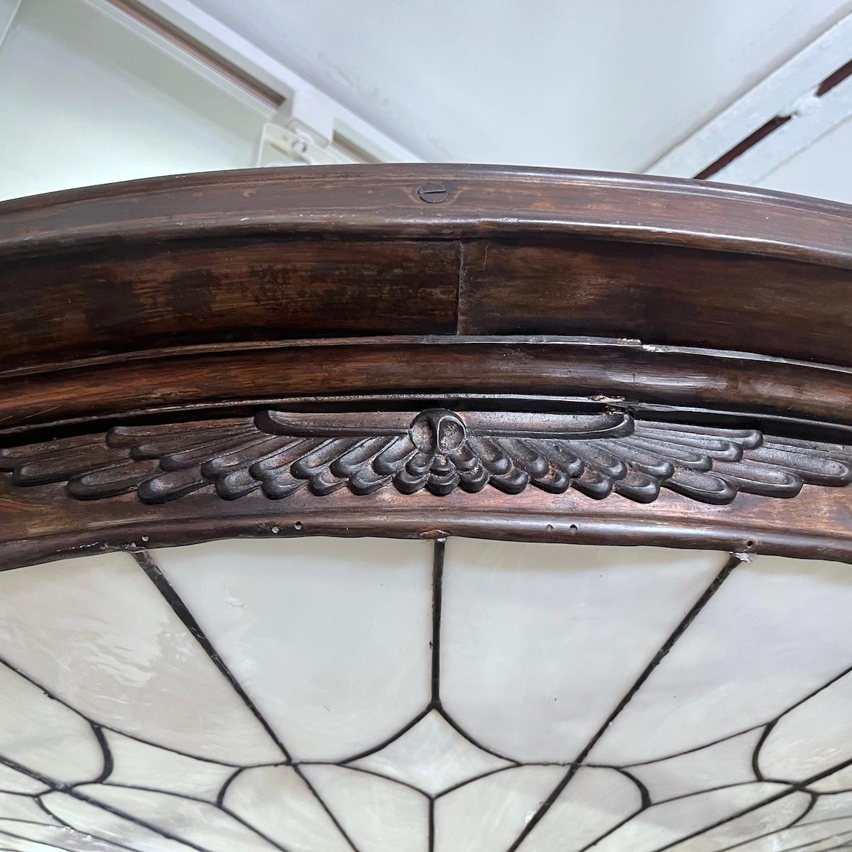 A set of four circa 1920's English leaded glass light fixtures with wings of Godess Isis on antique bronze frame. Could be a flush mount or pendant fixture. 8 interior lights. Sold individually.

Measurements: 
Height: 10