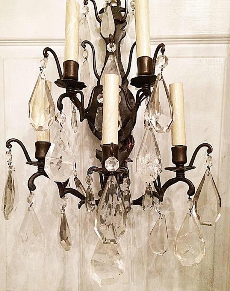 A set of six French circa 1930’s patinated bronze and rock crystal 5-light neoclassic style sconces. Sold per pair.

Measurements
Height 21?
Width 13?
Depth 8?