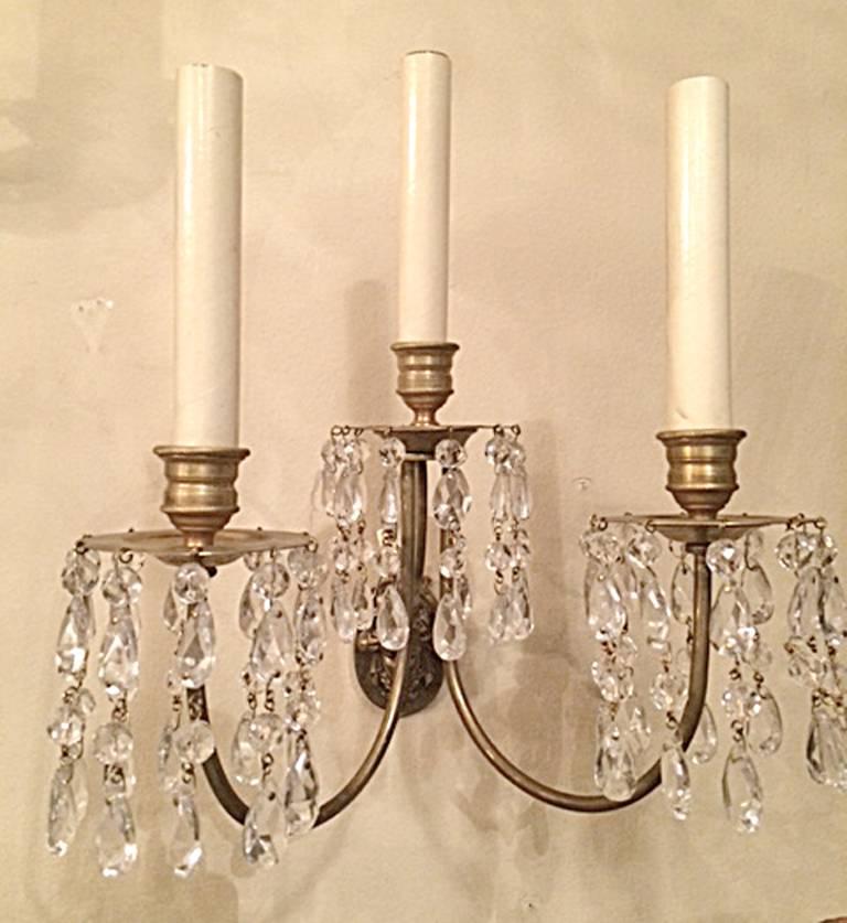 Set of eight circa 1920's American neoclassic style three-arm gilt bronze sconces with crystal drops. Sold in pairs.

Measurements:
Height: 13.5