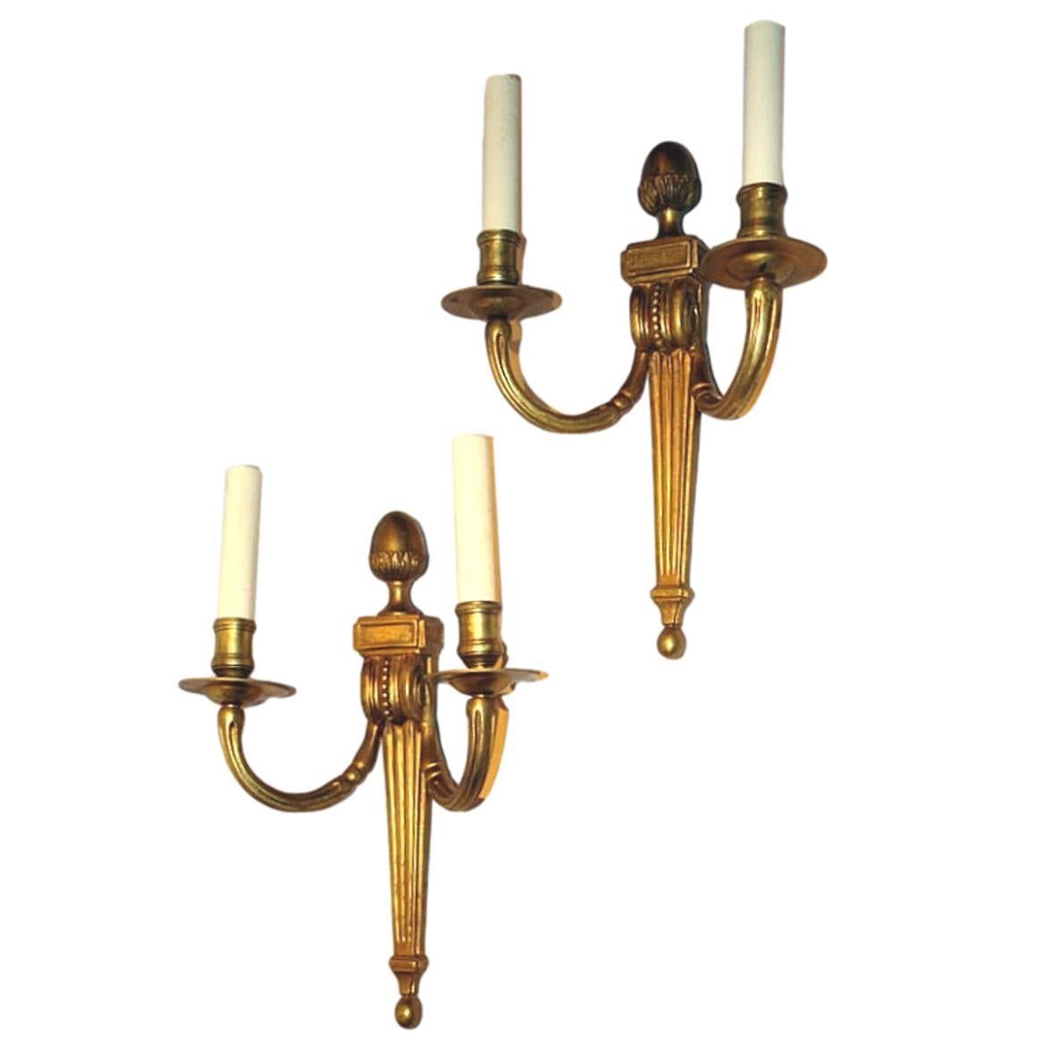 Set of eight circa 1920's French neoclassic style gilt bronze double light sconces with acorn crowning the top and with tapered and fluted body. Sold in pairs.

Measurements:
Height: 13