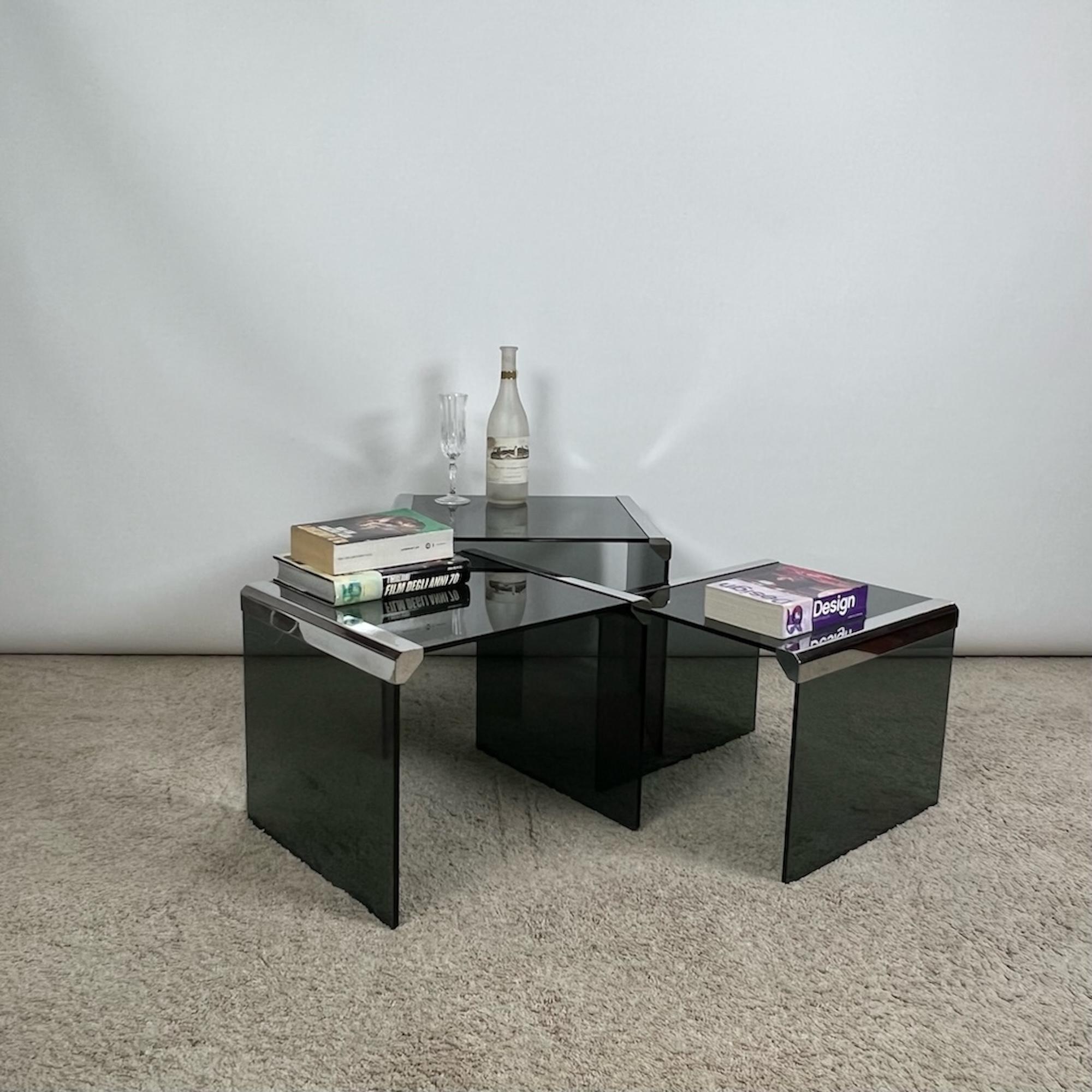 Beautiful set of three nesting tables designed by Pierangelo Gallotti in 1975 and manufactured by Gallotti & Radice in the 70s.

This iconic tables are made of ultra thick fume gray crystal with chrome metal details.

In the typical Hollywood