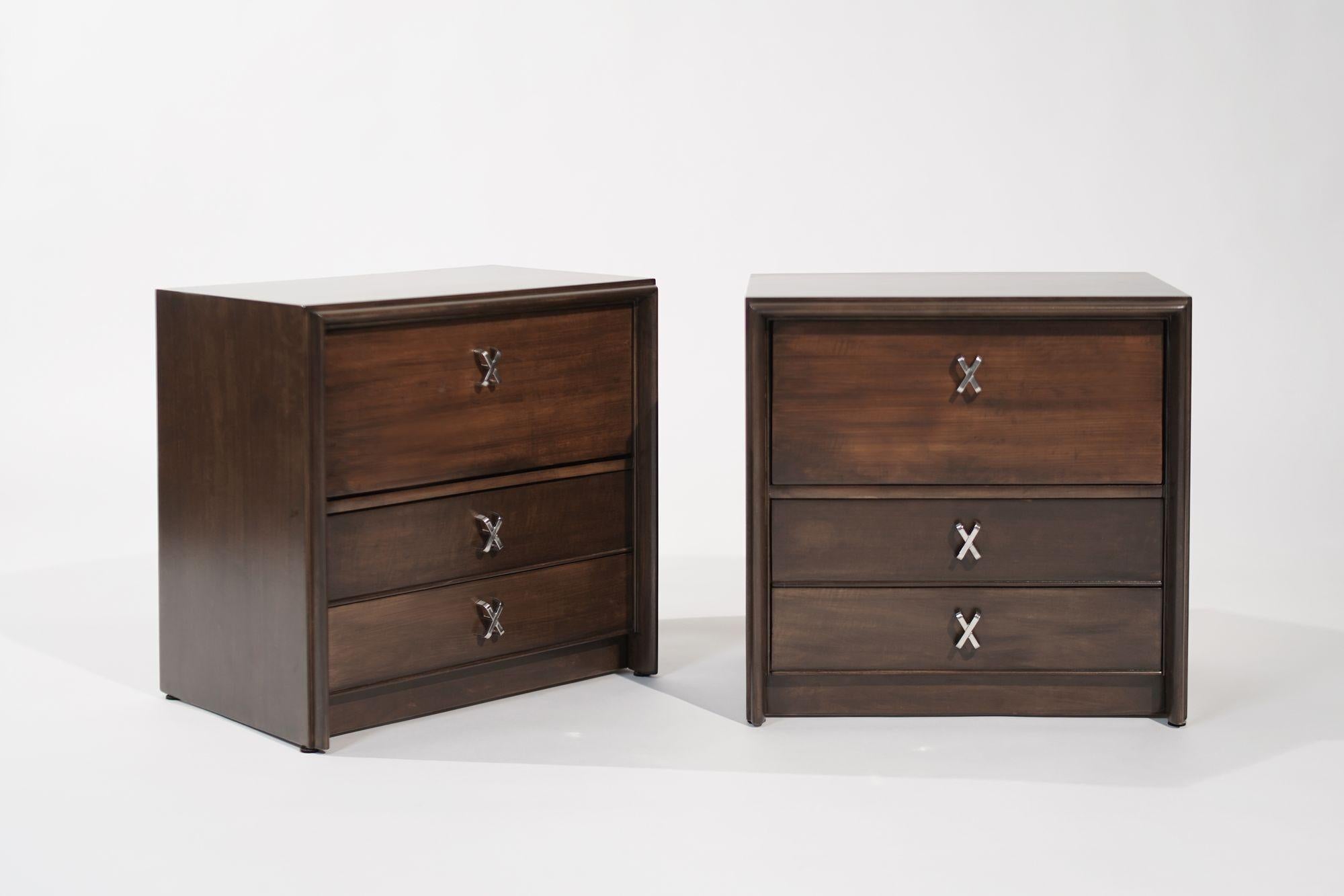 Meticulously restored Vintage Nightstands by Paul Frankl for Johnson Furniture, circa 1950s. These mid-century gems feature a drop-down door storage shelf and two drawers, each adorned with x-shaped nickel hardware. Blending iconic design with