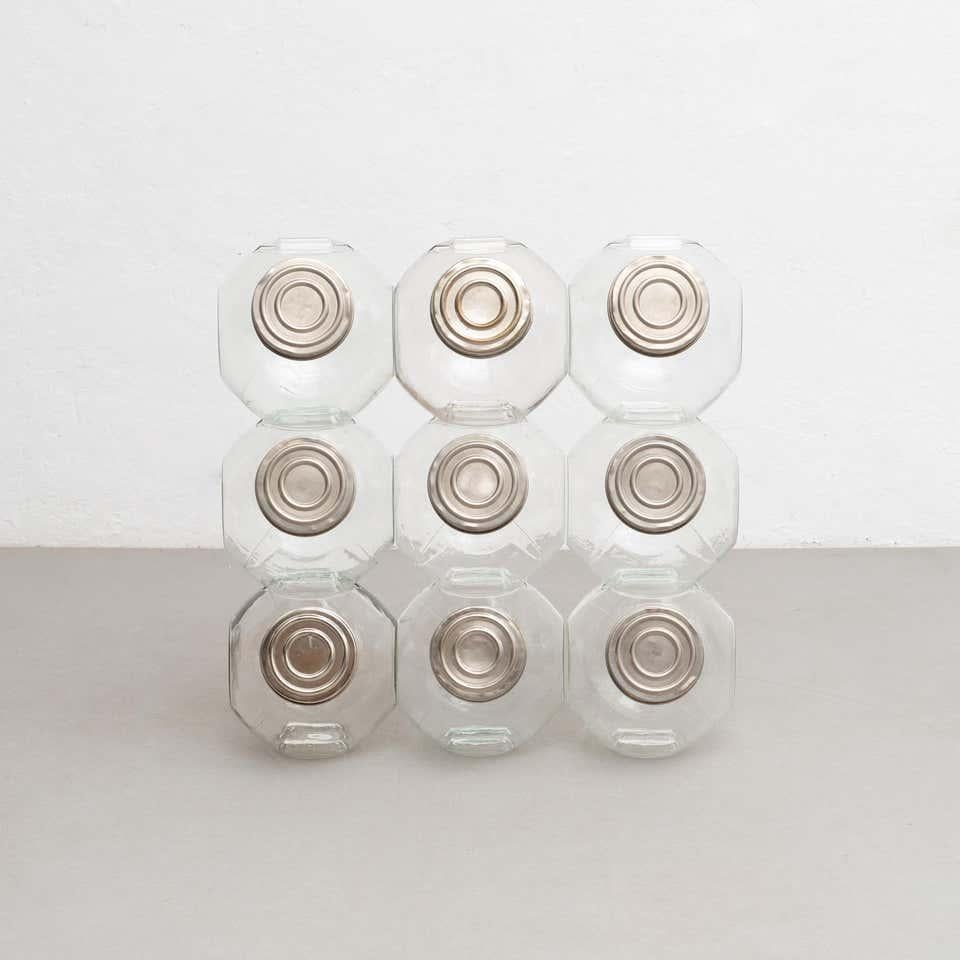 Antique stackable set of 9 glass containers with a metal cap. 

Made by unknown manufacturer in Spain, circa 1930.

Each measurements:
D21 x W26 x H23 cm

In original condition, with minor wear consistent with age and use, preserving a