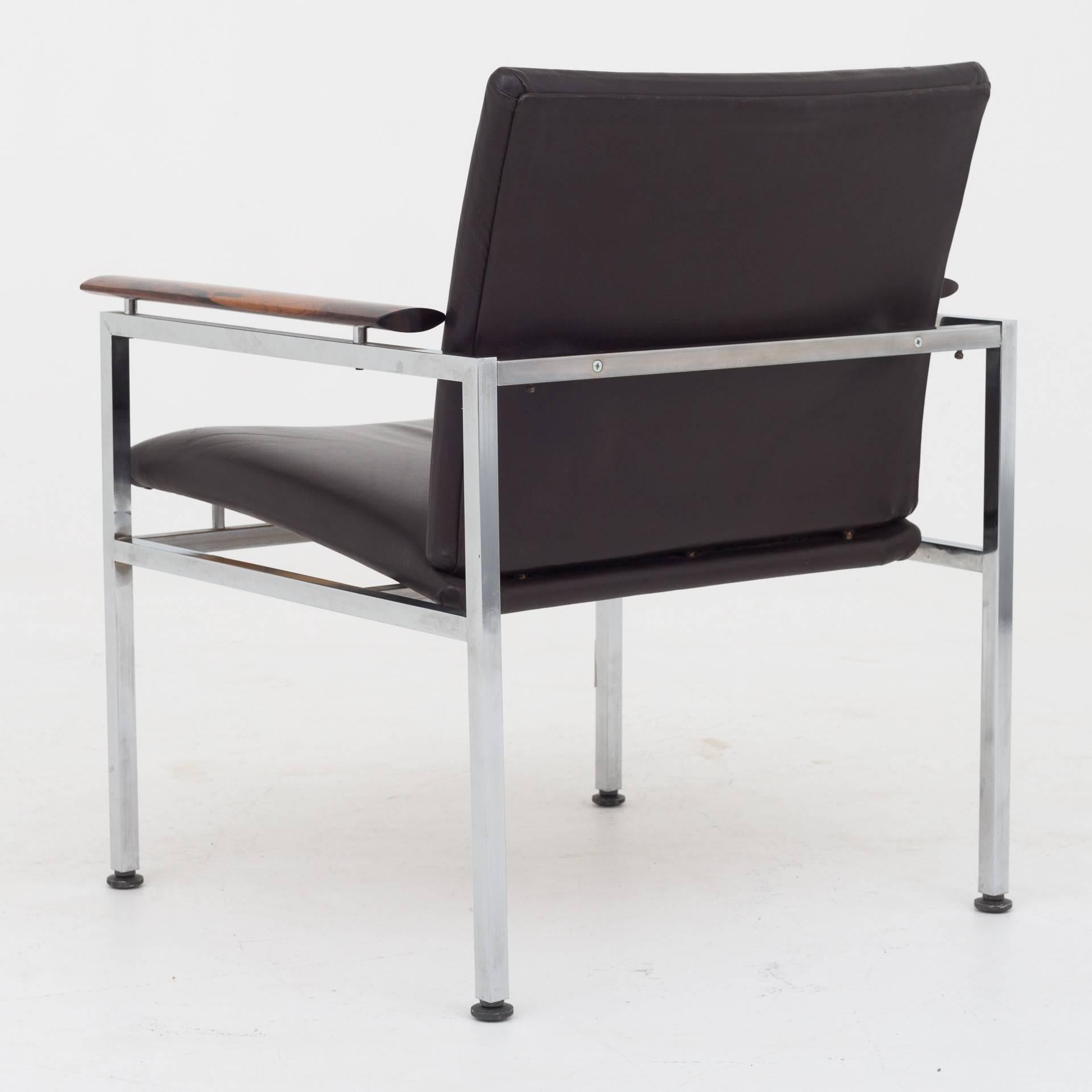 Nine armchairs with frame of chromed steel, armrests in rosewood and seat of black leather. Maker P. Schultz.