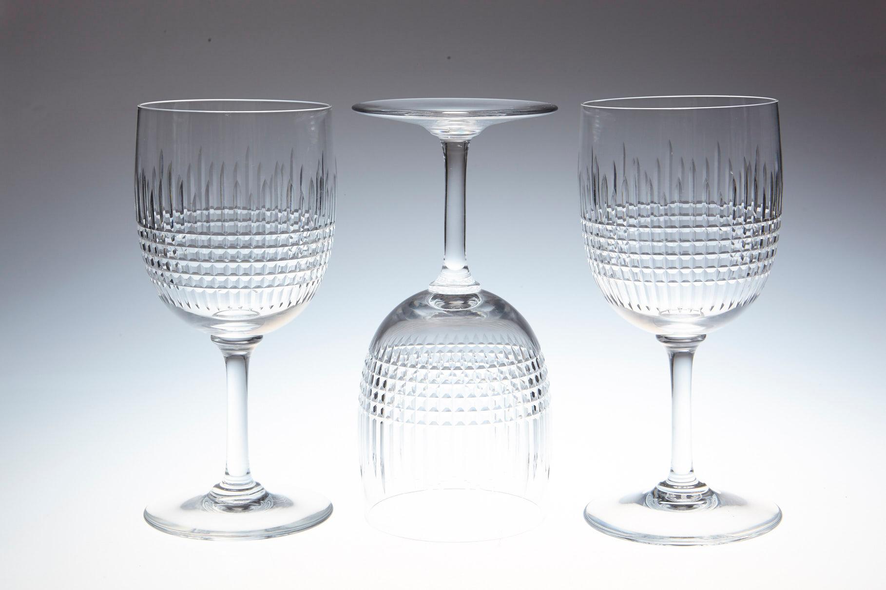 Rare set of nine Baccarat crystal white wine glasses in the 'Nancy' pattern.
This classical shape with finely banded vertical and horizontal cuttings is one of Baccarat crystals most popular patterns, first created in 1909 but is discontinued