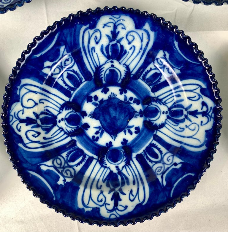 This set of nine blue and white Dutch Delft dishes were made in the 18th century circa 1770. The hand-painted design features a tulip bulb in the center and tulips in a circle on the wide border. But, it is the exquisite deep cobalt blue and the