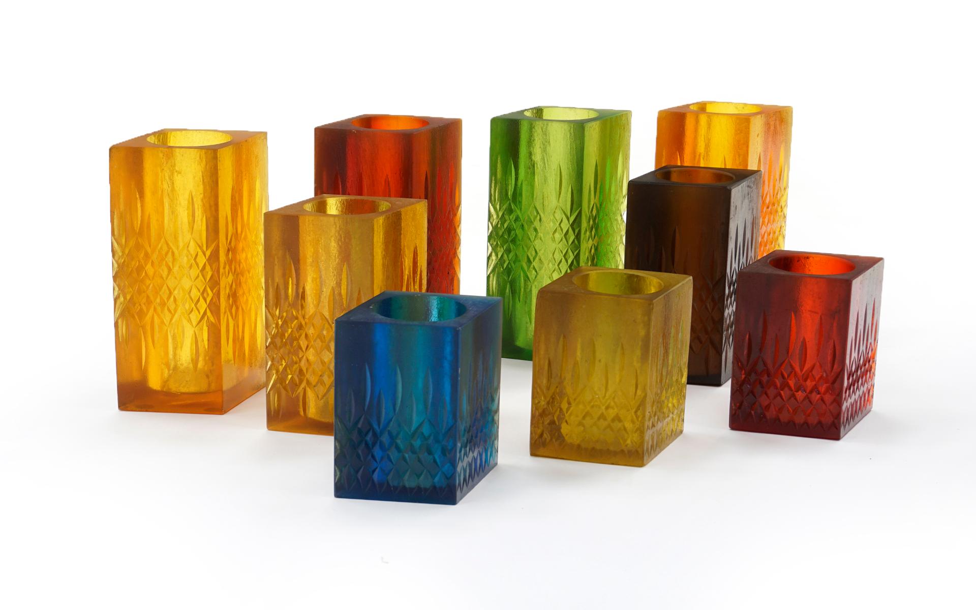 Set of 9 vases / candleholders by Sascha B. (Brastoff). Etched signature at underside. Mulitple colors including red, green, blue, and amber. Each is made of formed resin that is somewhat transparent so the look of these changes depending on the