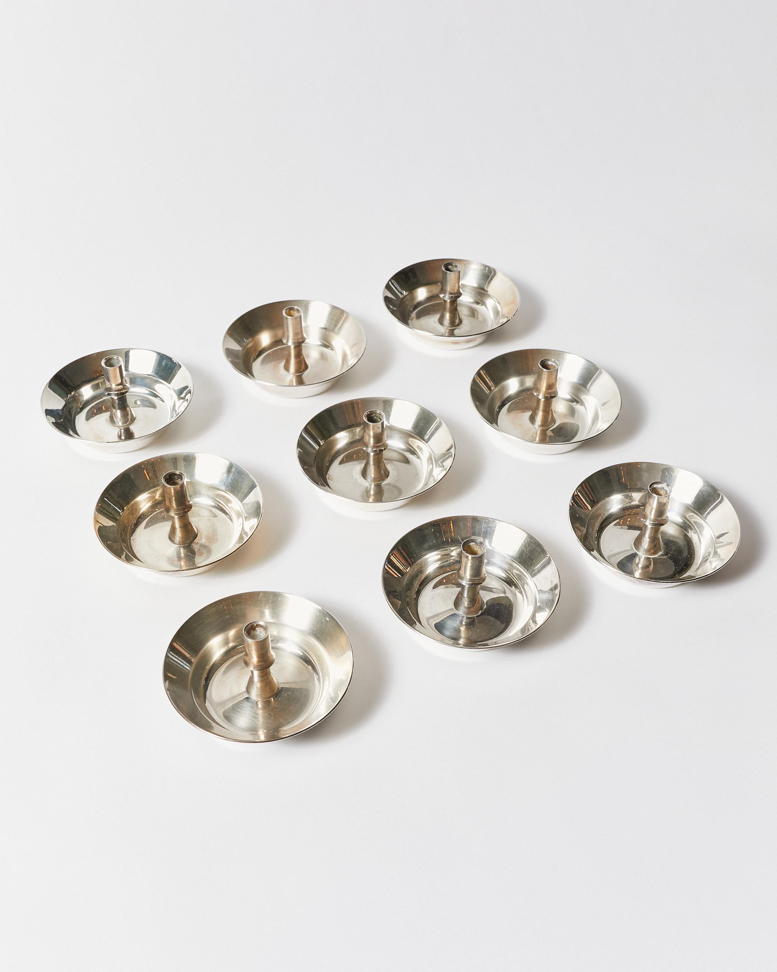 Set of nine silver-plated 'saucer' candle holders. The set can work in both, causal and formal settings. Designed by Jens Quistgaard and produced by Dansk Designs Copenhagen.