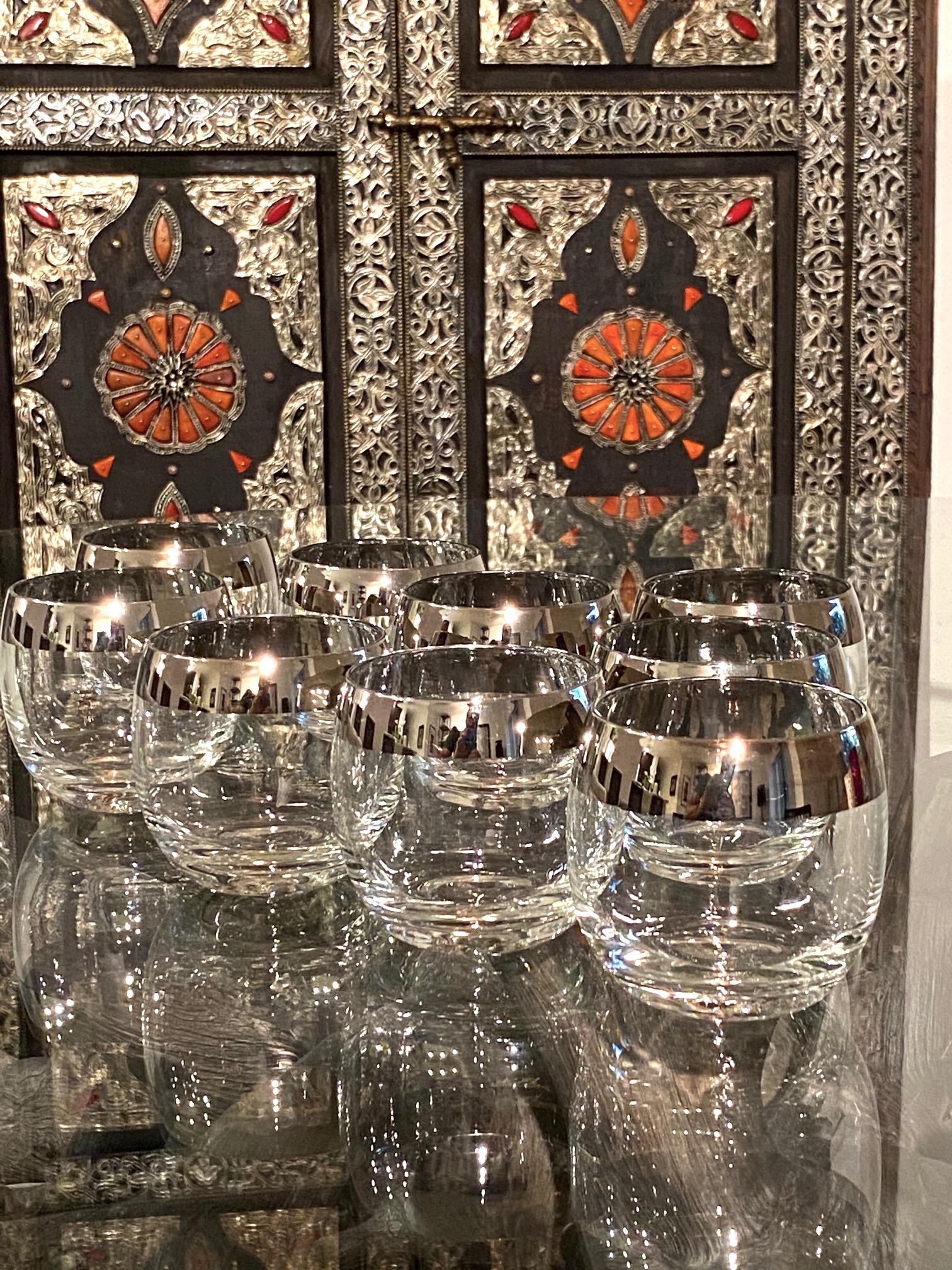 Set of nine vintage cocktail glasses designed by Dorothy Thorpe, known for her iconic Mid-Century Modern barware and glassware designs. The round glasses have a minimalist design with silver overlay rims. The large whiskey glasses are often referred