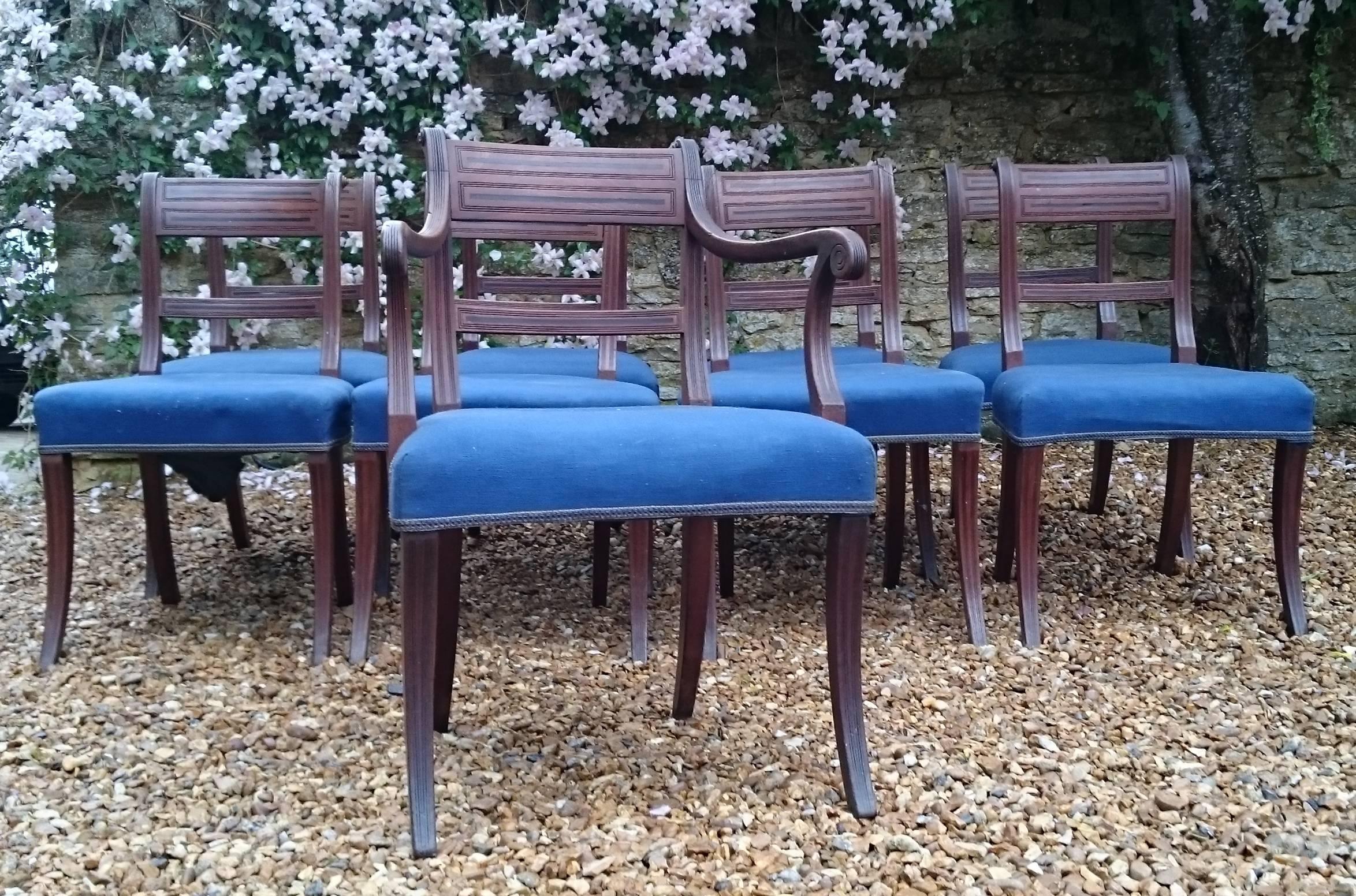 Set of nine early 19th century mahogany antique dining chairs. This is a very fine set of chairs with close reeding to the top of the arms, roundels at the top and ebony inlay on the legs and back rails. It is good to see a set of chairs from this