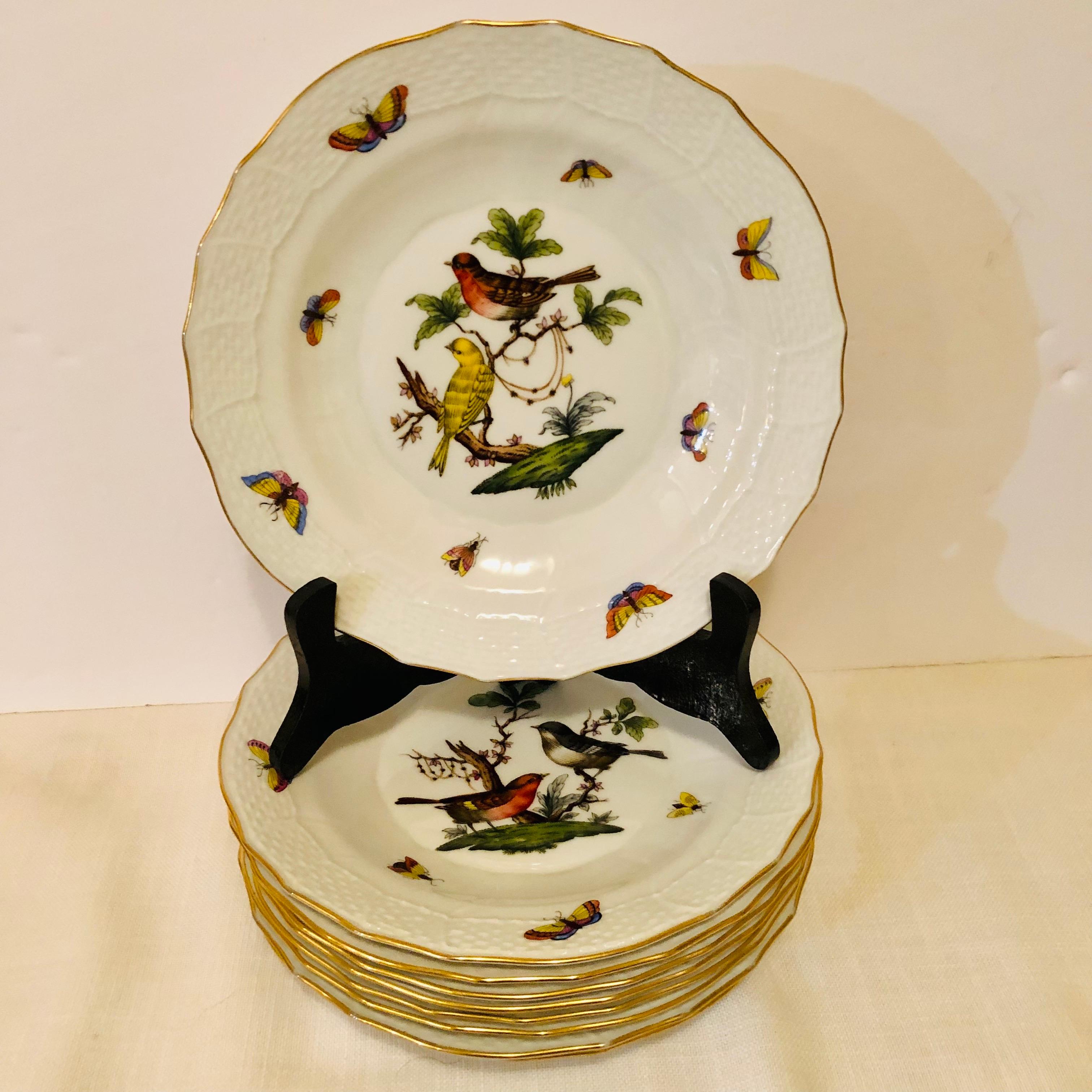 This is a lovely set of nine Herend Rothschild Bird dessert plates, each painted with two birds and decorated with accents of butterflies and flowers on a white ground. These would make a lovely naturalistic addition to any dessert service. The