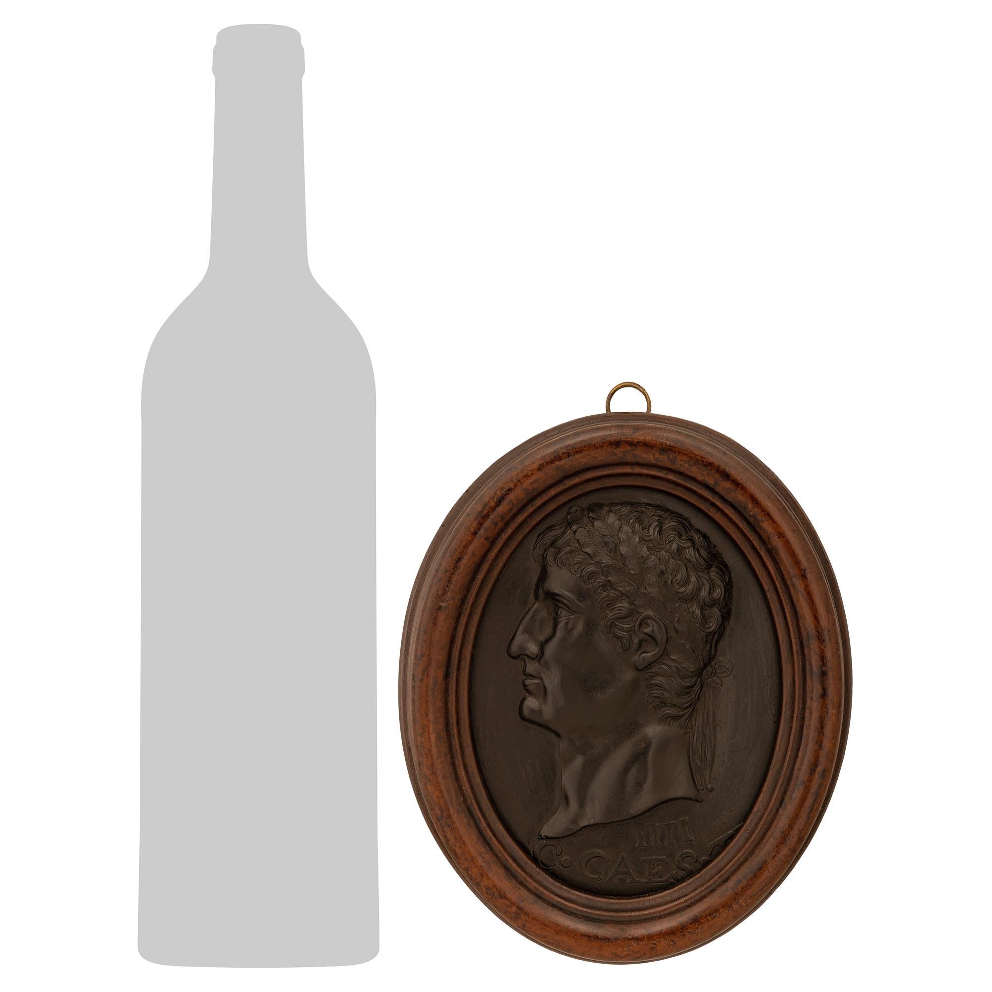 Ein historischer und beeindruckender Satz von neun italienischen Basalt Wedgwood und patinierten Holzplaketten aus dem späten 19. Jede Wedgwood-Plakette, die in einen gesprenkelten, ovalen, patinierten Holzrahmen eingefasst ist, stellt einen