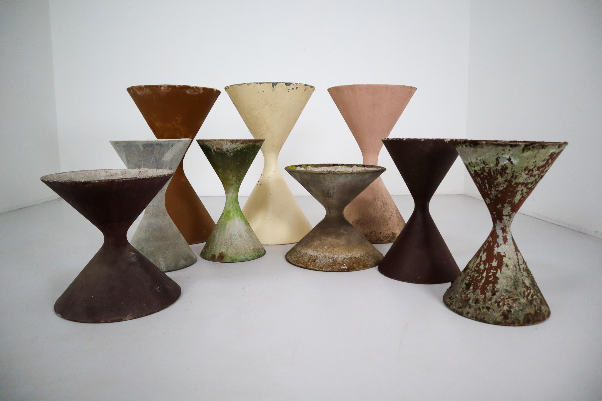Designed by the iconic Willy Guhl in the early 1950s, and made of fiber cement by Eternit, SA, these nine planters sport various shades of old, weathered paint and are in good condition. This unique hourglass shaped planters are fresh and modern