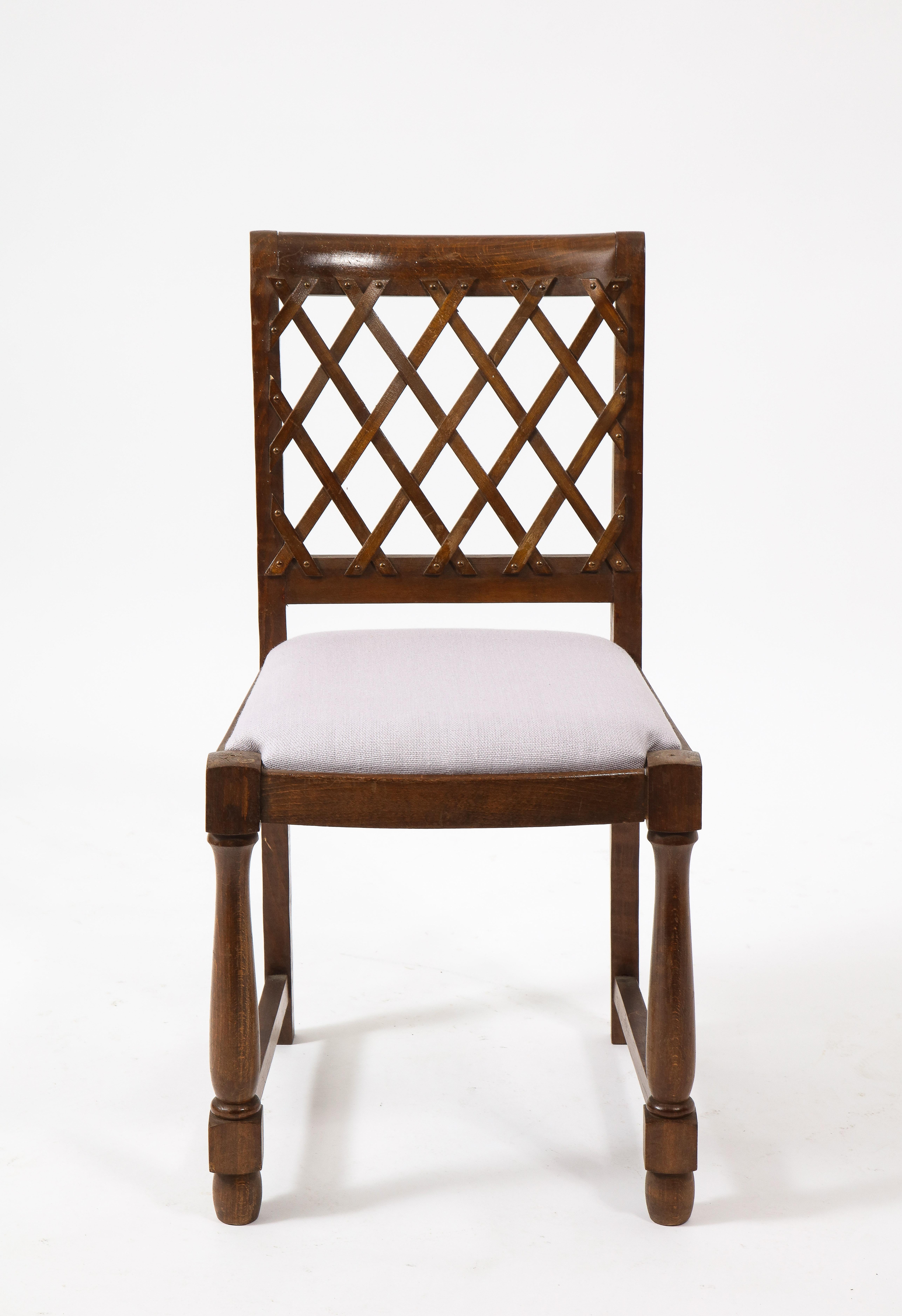 A set of elegantly carved oak side chairs with a lattice back.