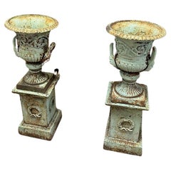 Set of old cast iron garden vases on a pedestal.