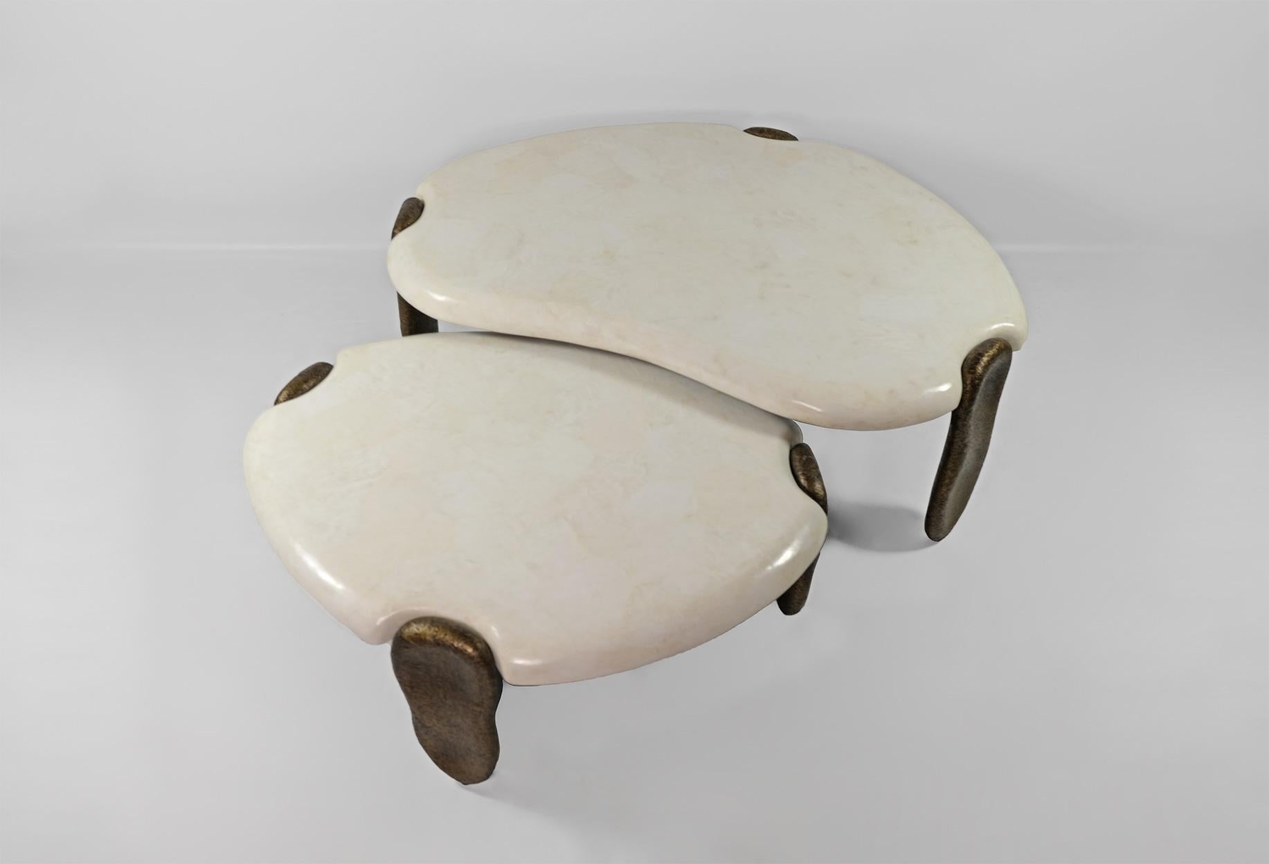 Das Set aus 2 Couchtischen besteht aus einer weißen Bergkristallintarsienplatte.

Jeder Tisch hat drei organische Beine aus rohem Fiberglas mit bronzefarbener Patina.

Die Oberseite der Tische ist an den Kanten abgerundet und verleiht ihnen einen