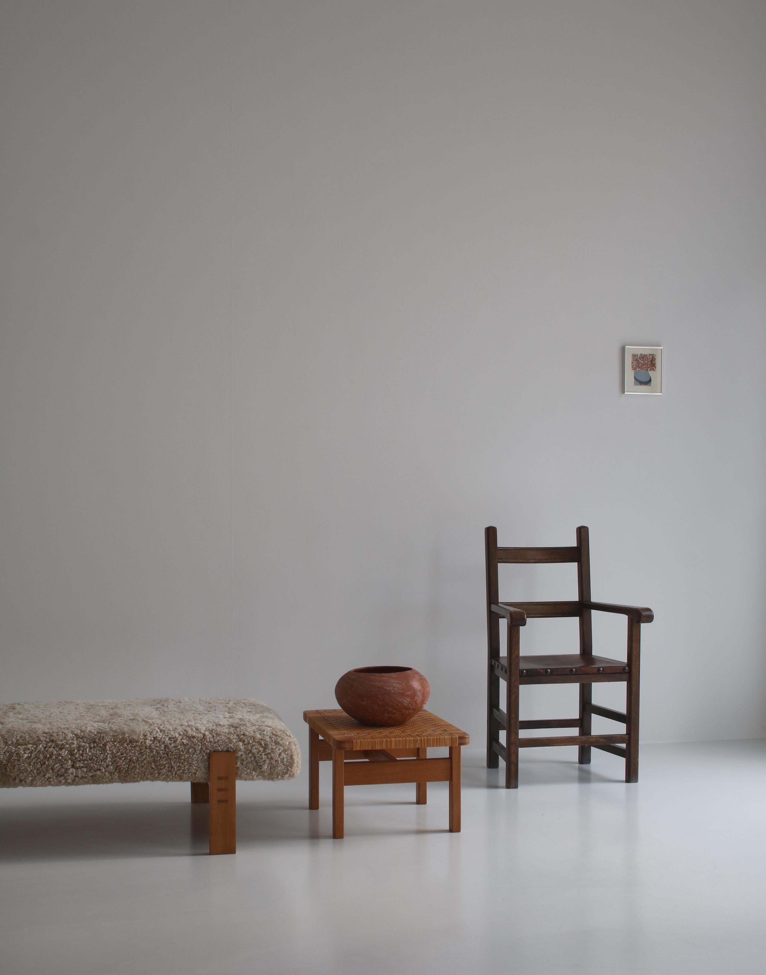 Merveilleuse paire de fauteuils réalisée au début du XXe siècle par un ébéniste danois inconnu en chêne teinté foncé et sièges en cuir patiné munis de gros clous en laiton. Très bon état d'origine. Design/One Elegant et habilement exécuté avec des