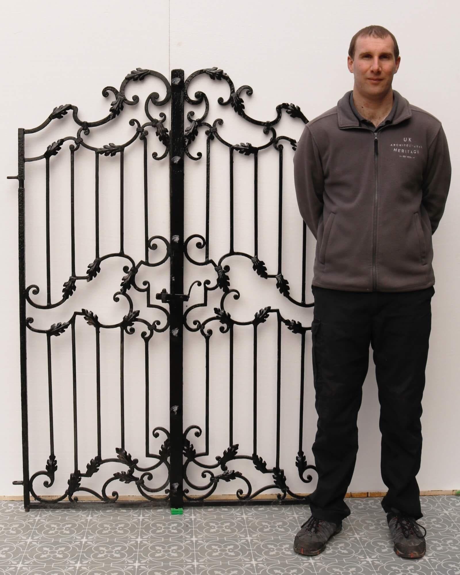 Ornately crafted with a series of scrolling patterns and ornamented with decorative oak leaves, this set of wrought iron garden gates make a stunning entrance to a patio, courtyard or secret garden. Dating from the 1850s, these gates are beautifully