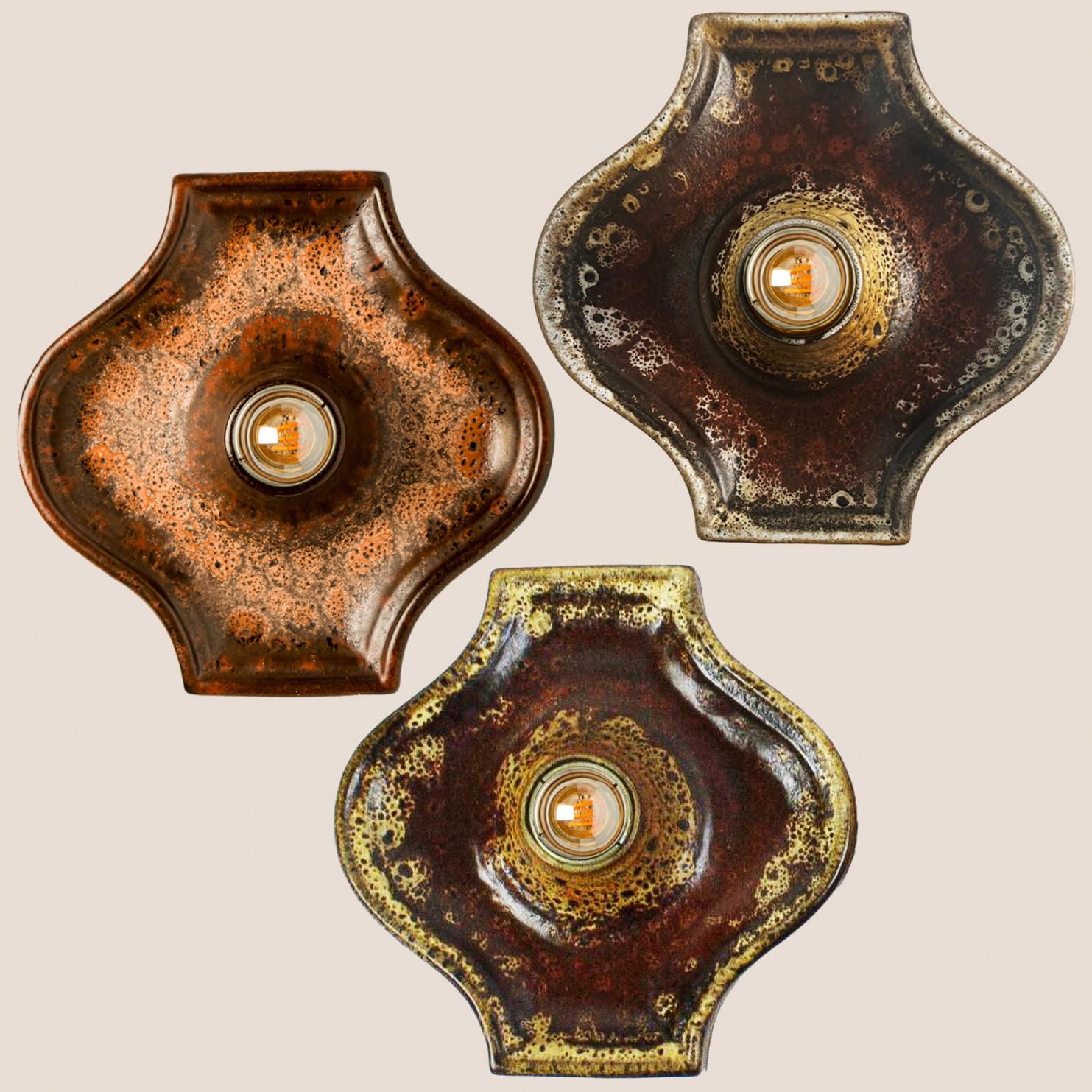 Precioso conjunto de apliques de cerámica roja, verde y marrón de estilo Fat Lava. Fabricado en Alemania hacia la década de 1970.

El estilo del glaseado se denomina 