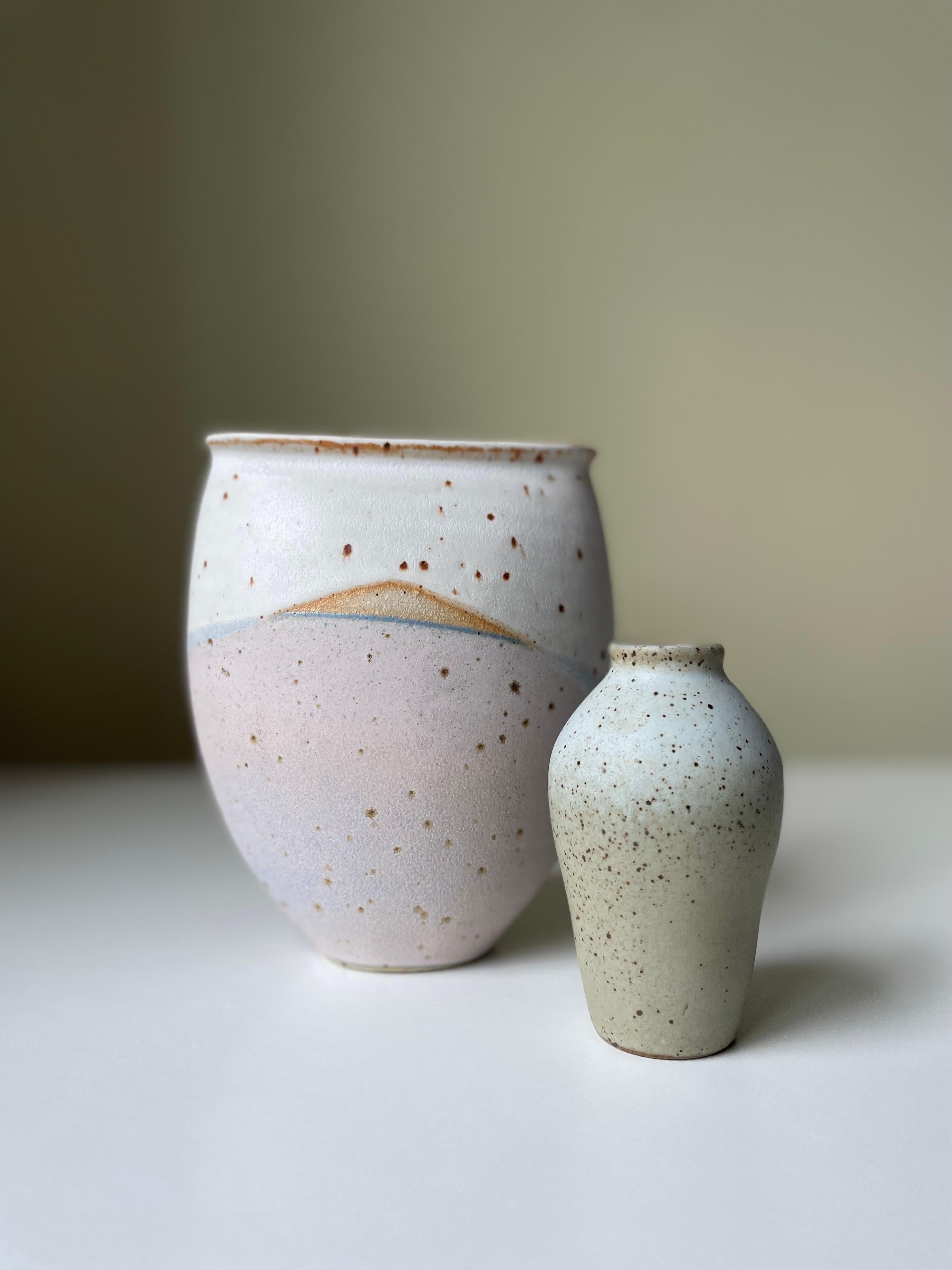 Set of two Scandinavian Modern light toned handmade soft shaped ceramic vases manufactured in Denmark in the 2000s. Large vase with organically lined dusty rose, light blue and chalk white matte glaze with brown accents. Small vase with light bluish