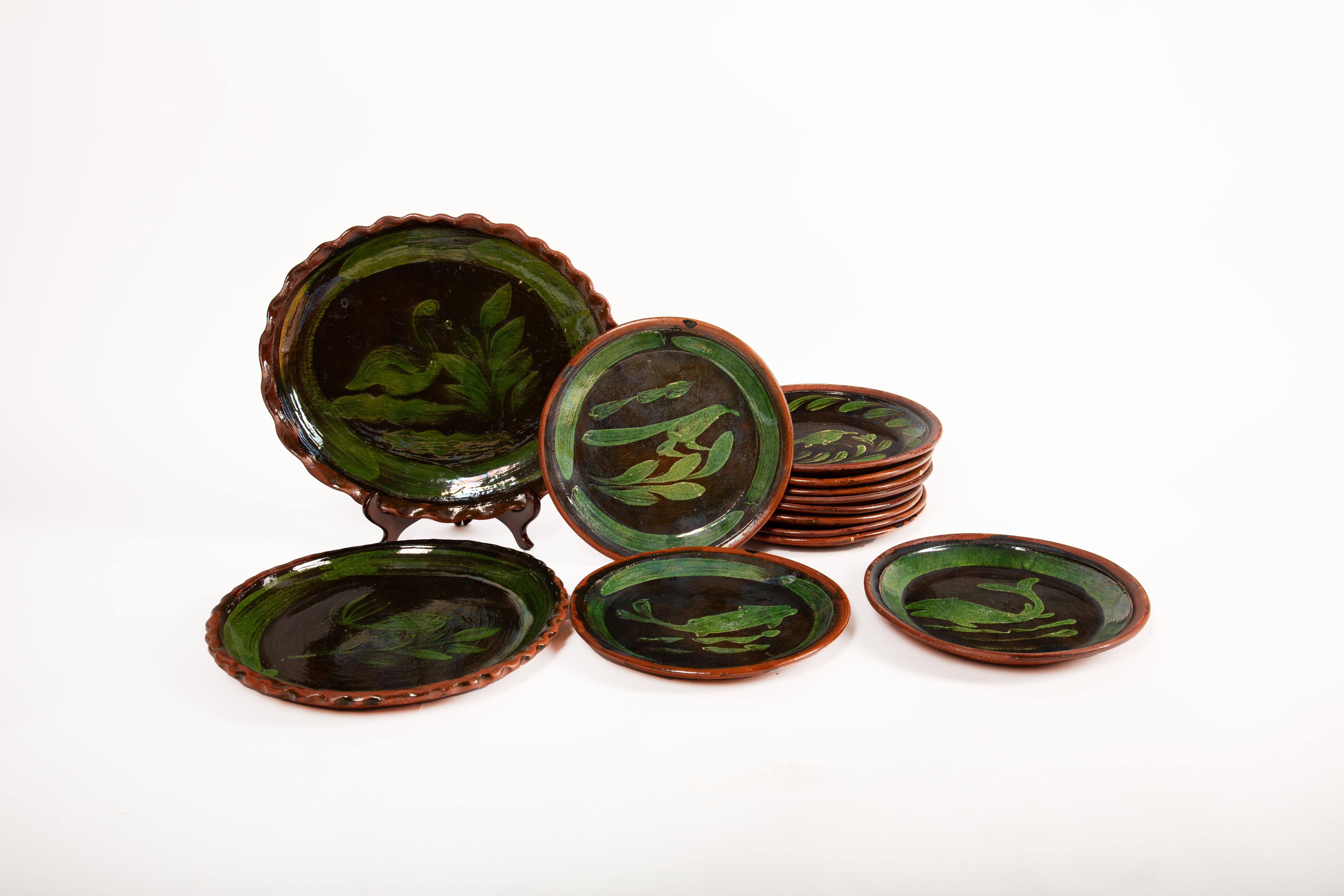 This vibrant set of Mexican folk art plates hails from Patamban, a town in Michoacán renowned for its deeply rooted ceramic traditions. Handcrafted from redware pottery, each plate features a rich reddish-brown clay body adorned with vivid green