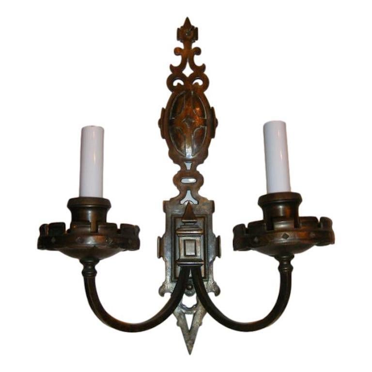 Set of four circa 1920s English patinated bronze heraldic double light sconces with original patina. Sold per pair.

Measurements:
Height 16