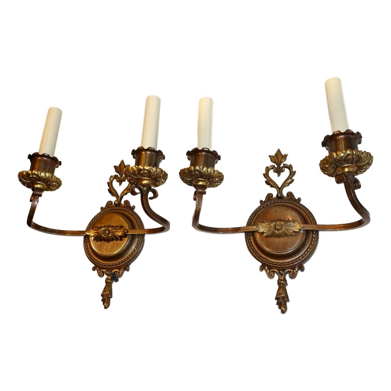 Set of four circa 1930's French neoclassic style patinated bronze sconces with a dark patina and foliage details. Sold in pairs.

Measurements:
Height: 12