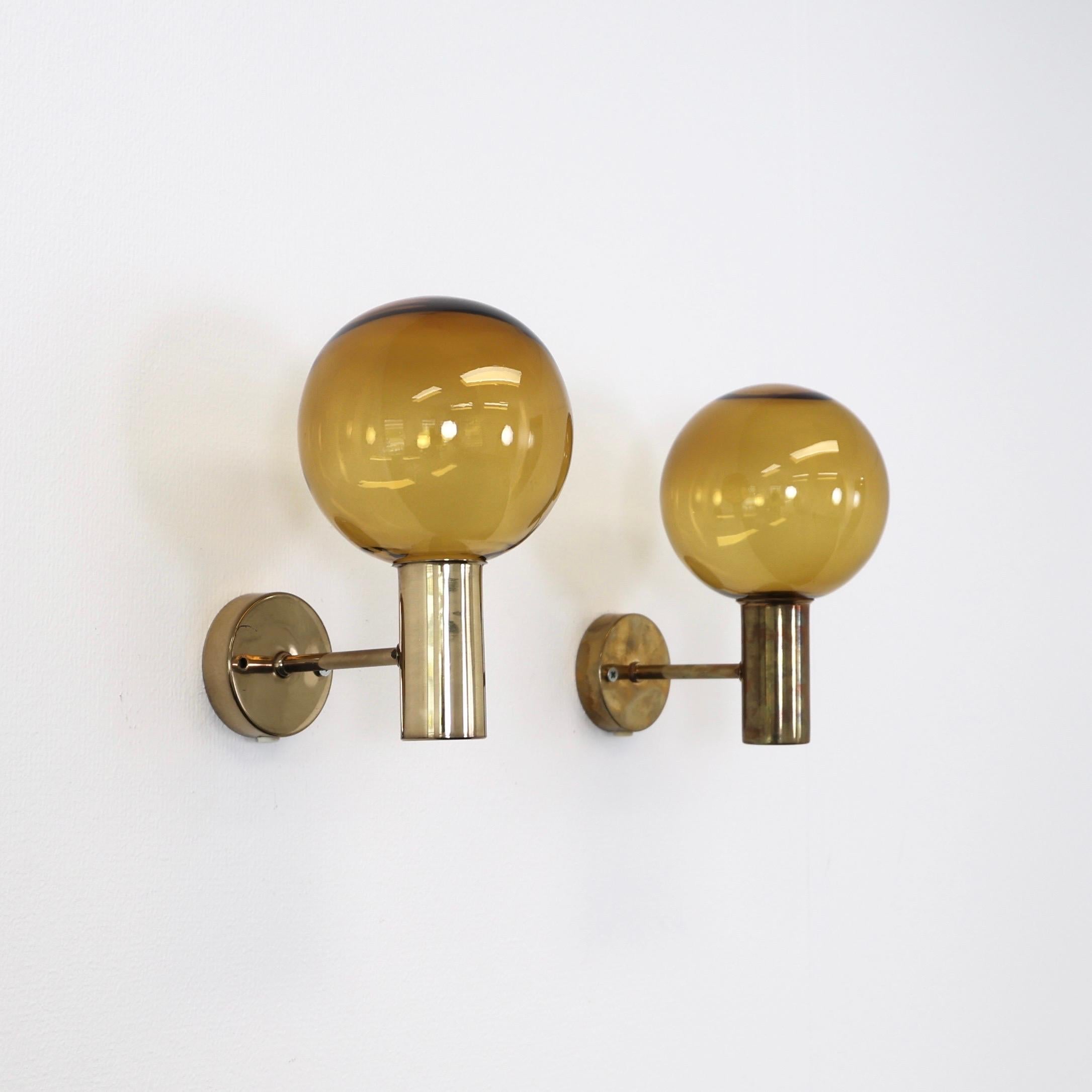 Set di applique in ottone con paralumi in vetro marrone dorato realizzate da Hans-Agne Jakobsson negli anni Sessanta.  

* Coppia (2) di appliques in ottone con paralumi in vetro marrone dorato
* Designer: Hans-Agne Jakobsson
* Model No: V149