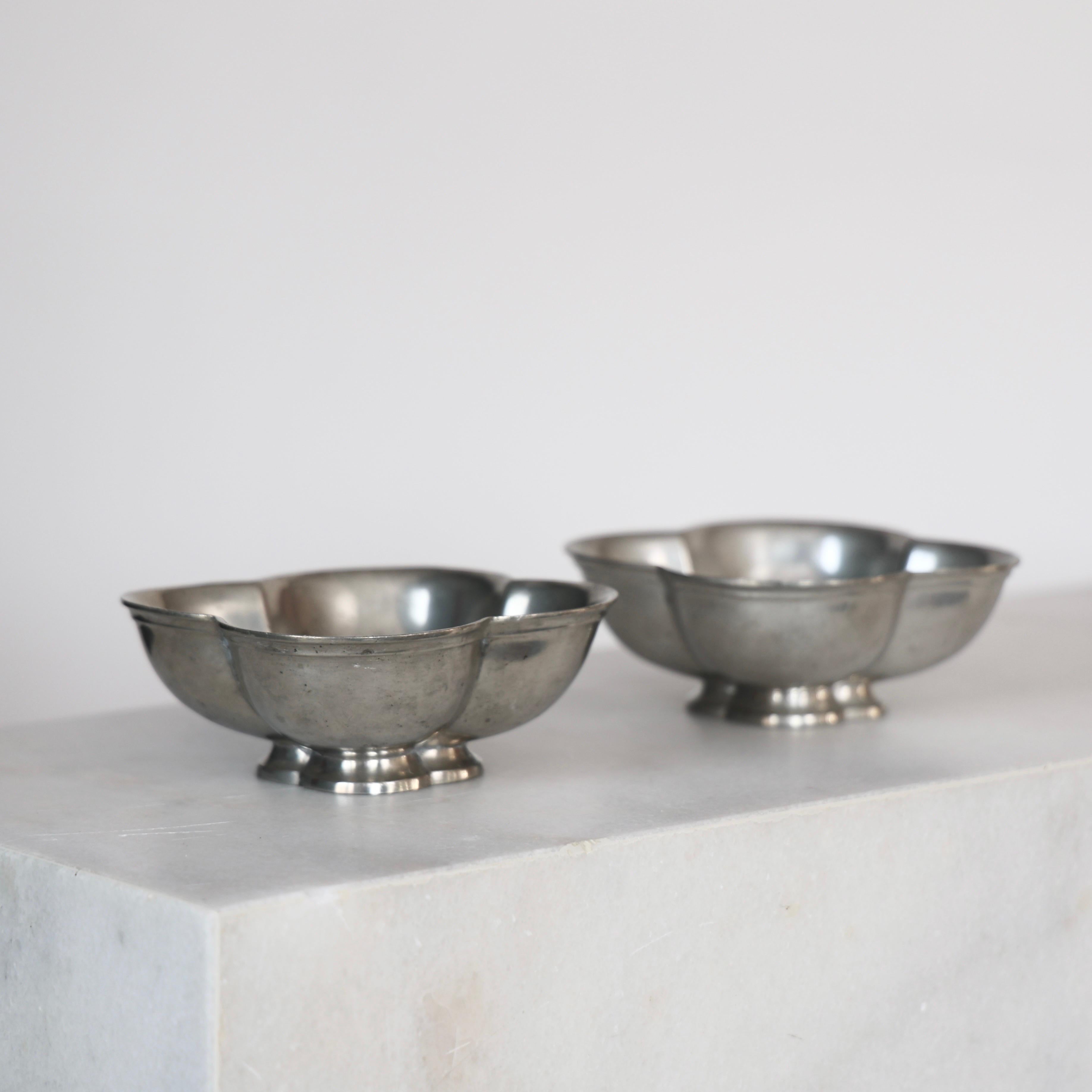 Set Pewter Bowls designed by Just Andersen in the 1920s. A fine duo for  a beautiful place.

* Set (2) of curvy pewter bowls on foot 
* Designer: Just Andersen
* Model: 1292
* Year: 1926-1929
* Condition: Fair vintage condition. Makers engraving